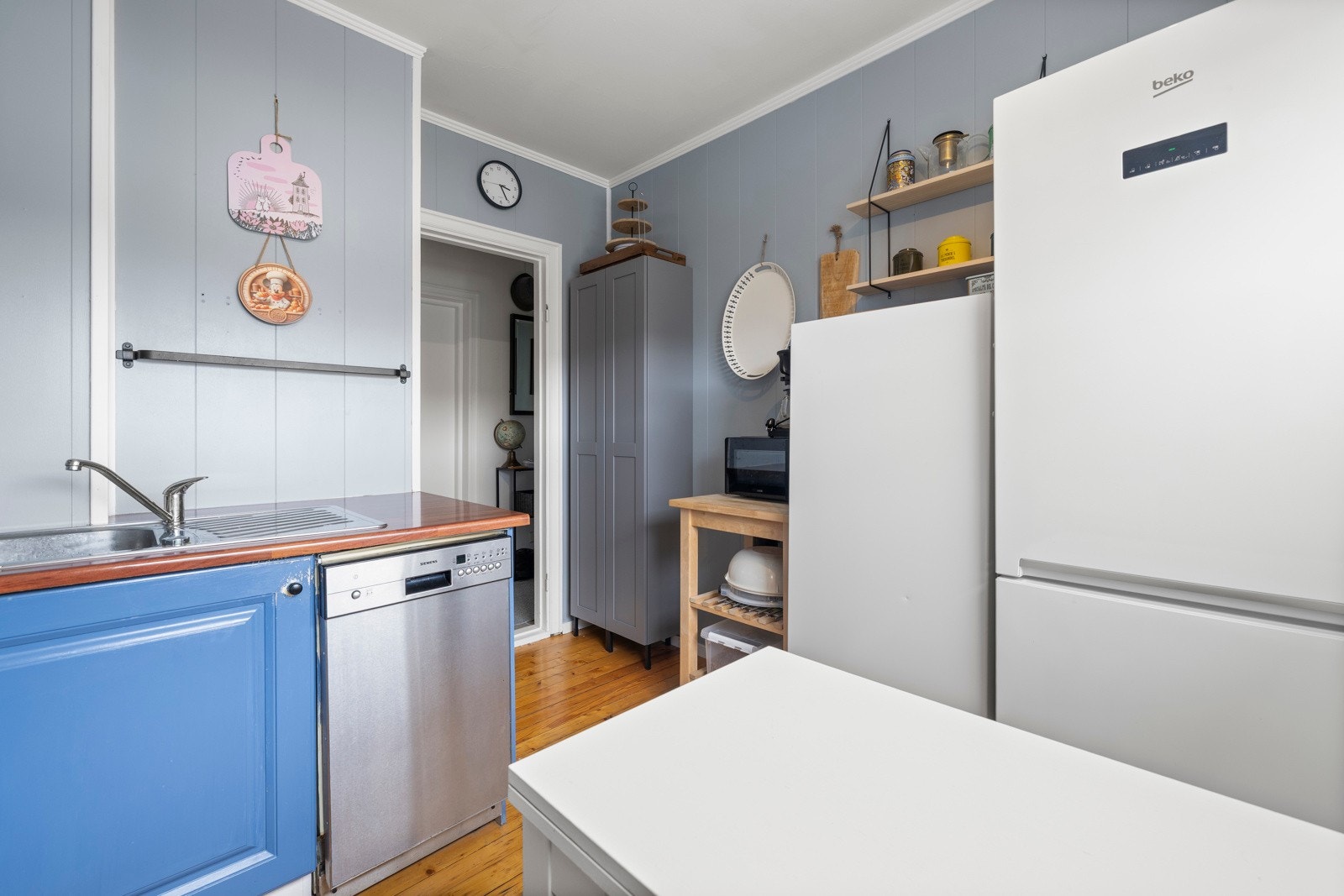 Rommet har tregulv, malte overflater og plass til spisebord under kjøkkenvinduet. Galleribilde