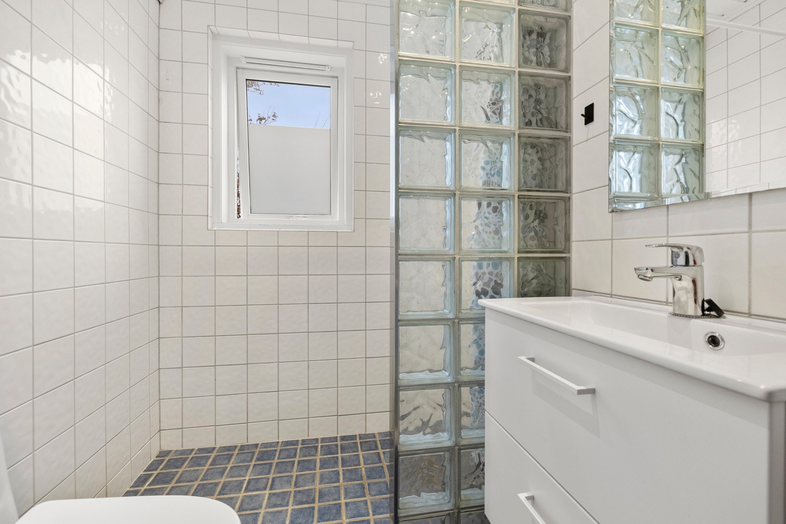 Flislagt bad med varmekabler i gulvet. Vask, armatur og toalett fra 2022. Galleribilde