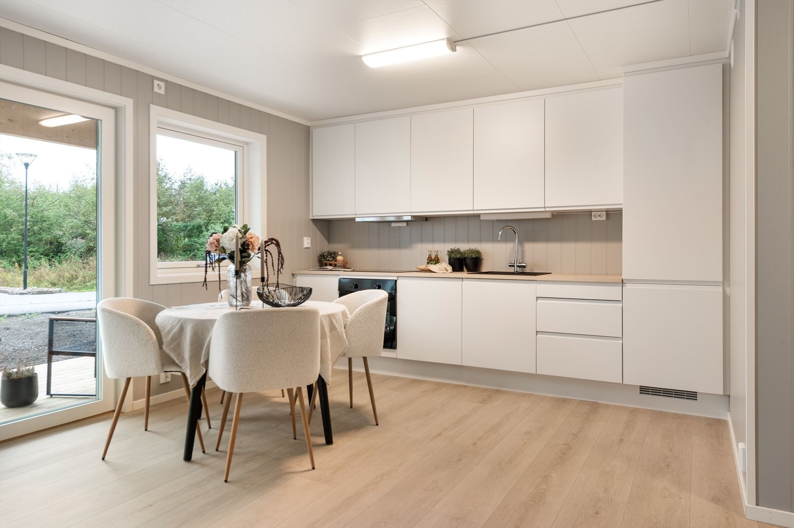 Lys kjøkkeninnredning med integrerte hvitevarer. Galleribilde