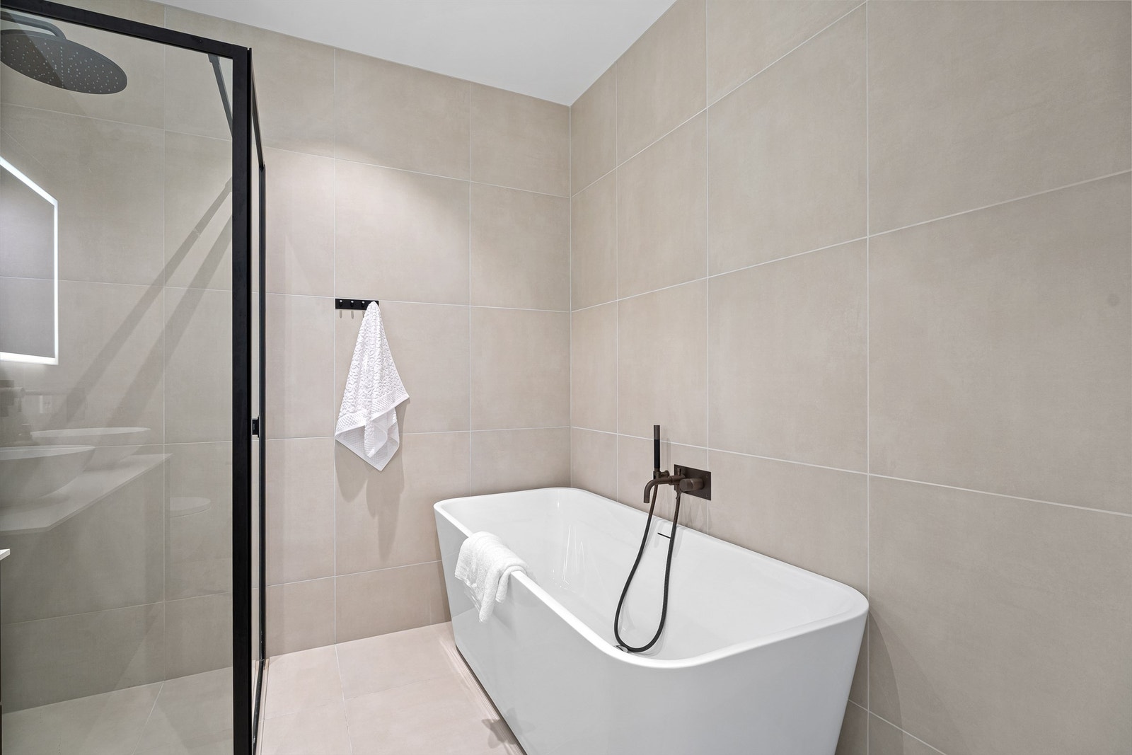 Dusjnisje med regndusj og integrert dusjhylle samt praktisk badekar. Galleribilde