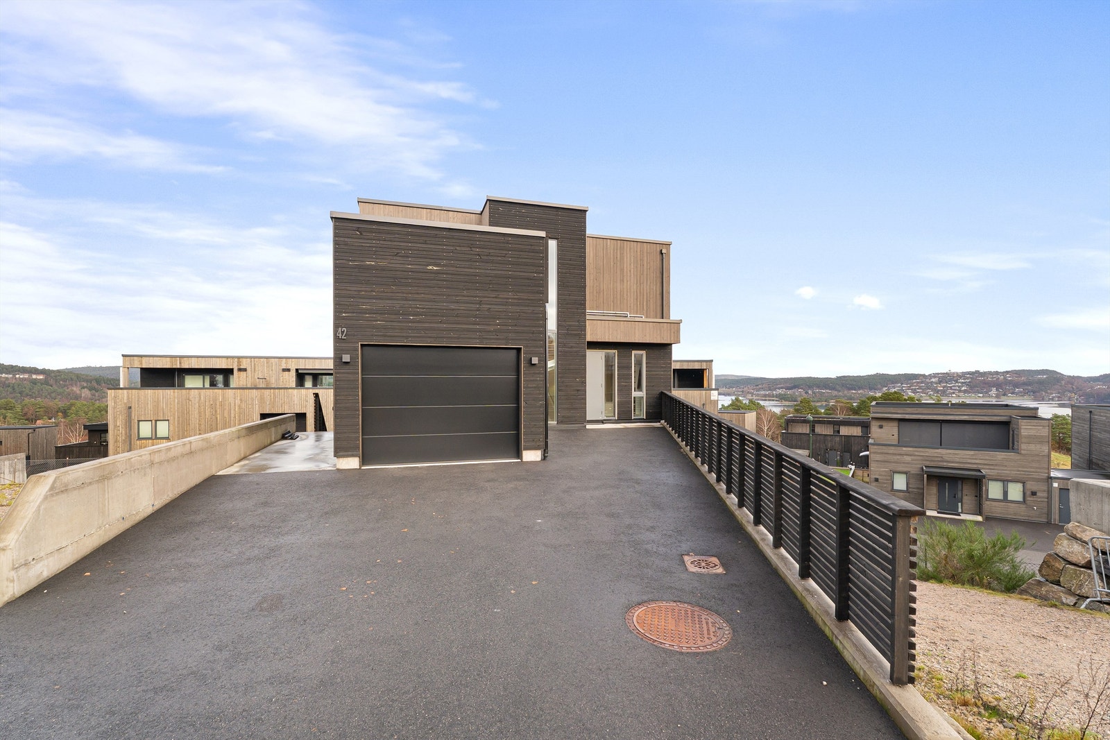 Det er garasje m/el-bil lader, og ellers flere biloppstillingsplasser på egen tomt. Til venstre er det trapp ned til hyblenes inngangsparti. Galleribilde