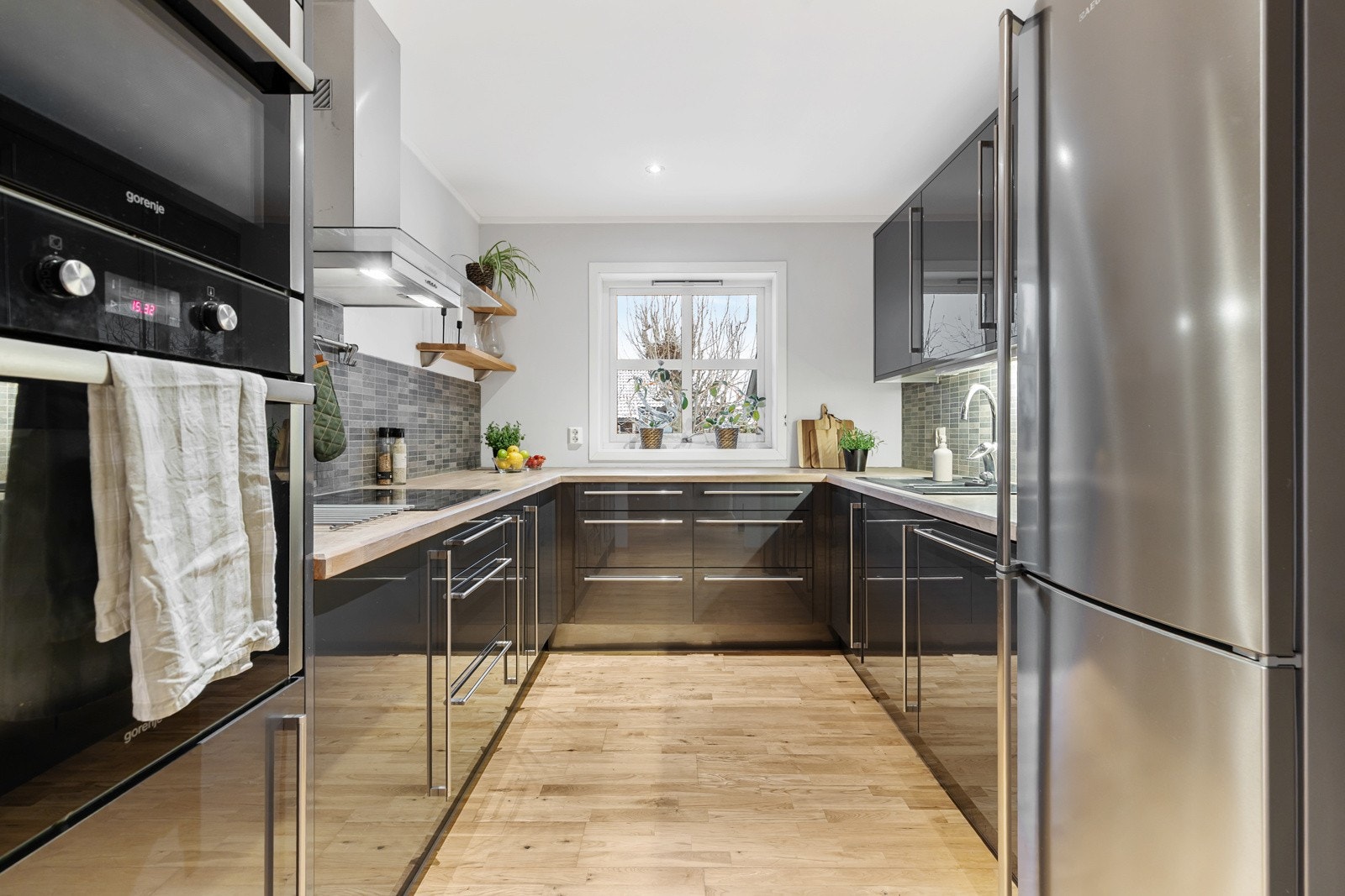 Praktisk utnyttet med innredning langs tre vegger og godt med både oppbevaring og arbeidsplass på benken. Galleribilde