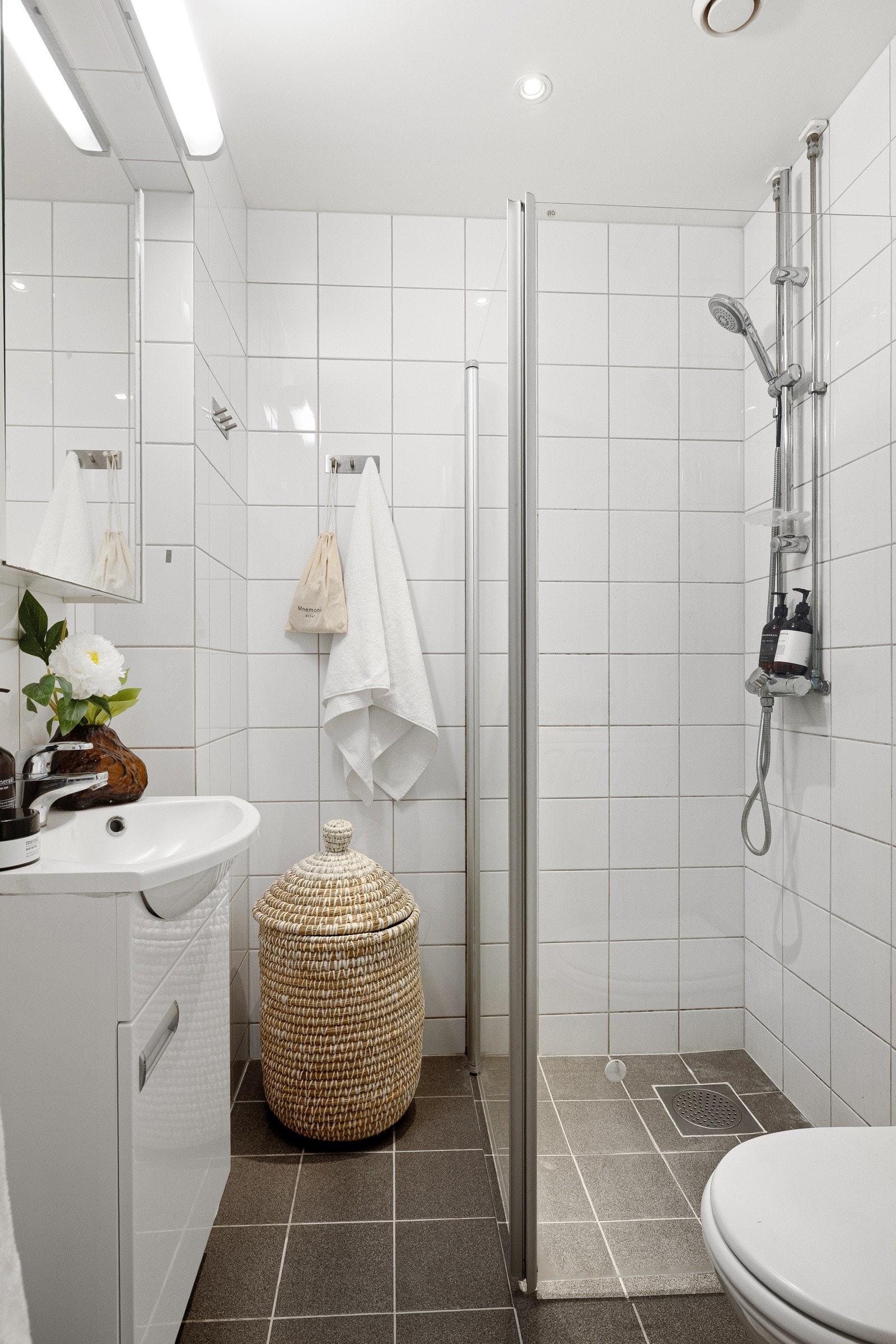 Rommet er utstyrt med dusjhjørne med innfellbare glassdører, servant med underskap, speilskap, toalett og opplegg for vaskemaskin. Galleribilde