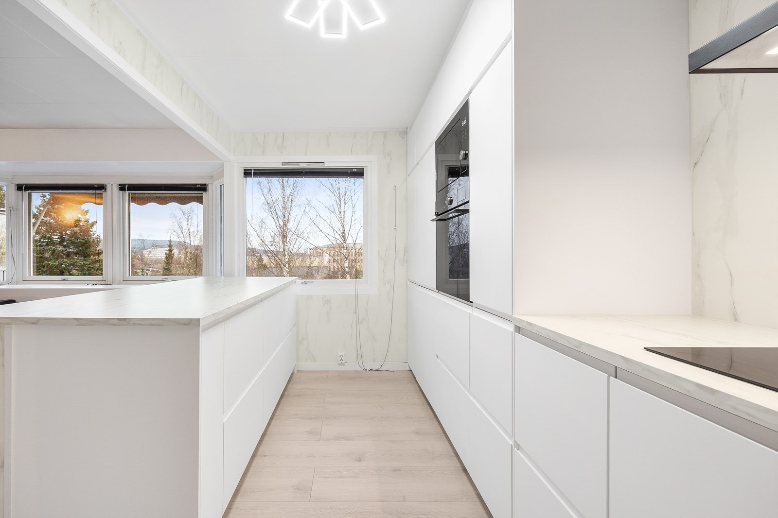 I innredningen er det integrerte hvitevarer som stekeovn og mikro i ståhøyde, platetopp, oppvaskmaskin og kombinert kjøle-/fryseskap Galleribilde