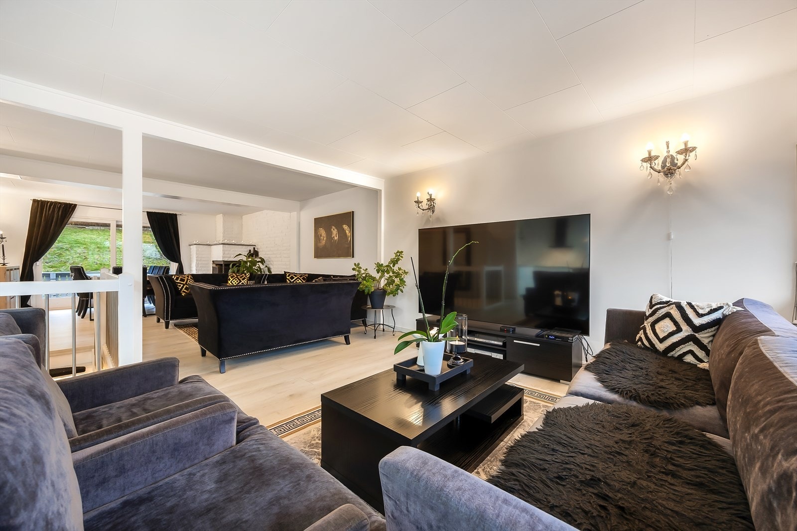 Den gjennomgående løsningen og de mange store vinduene gir stuen en lys og luftig atmosfære Galleribilde