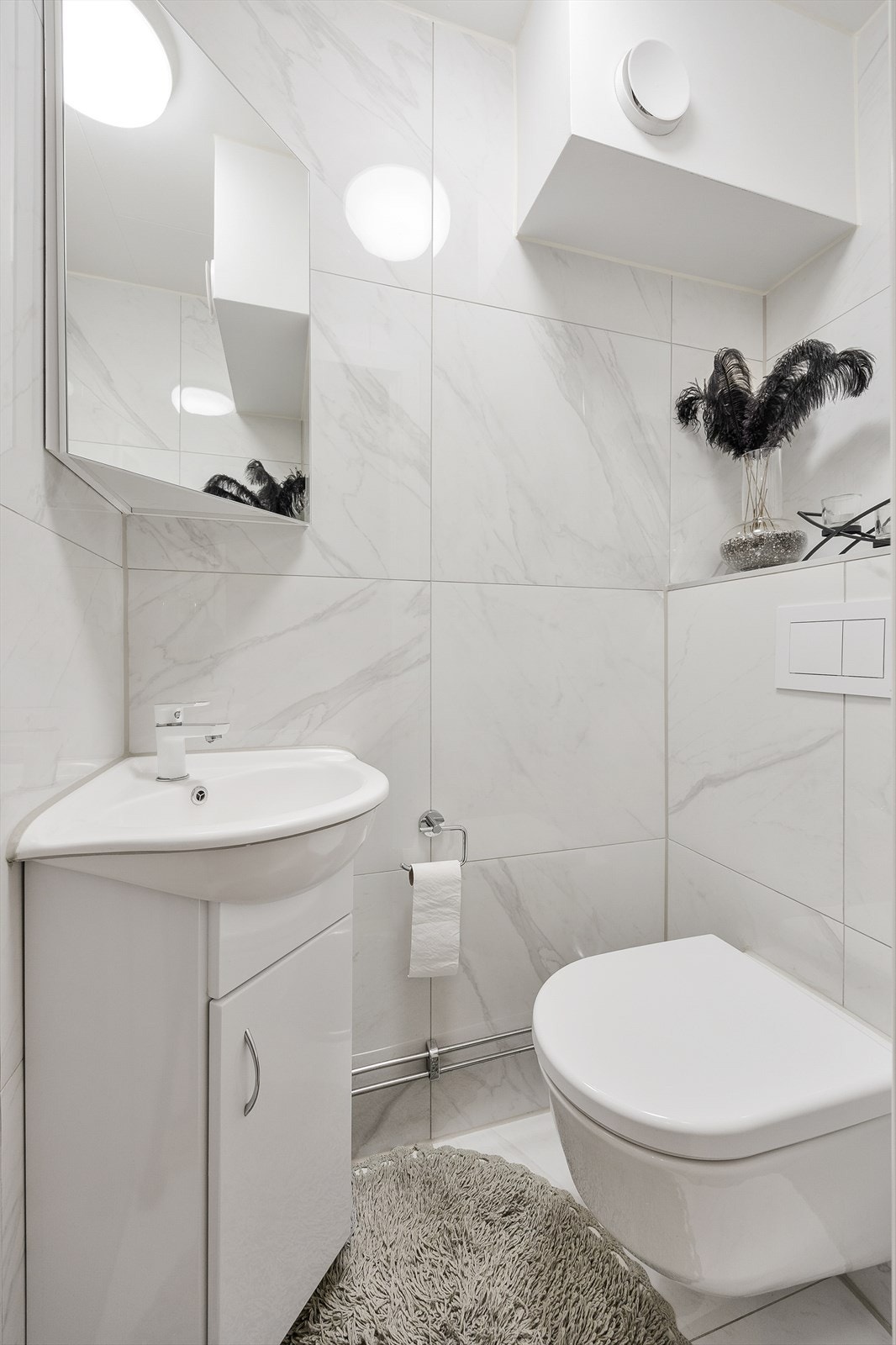 Separat gjestetoalett, utstyrt med vegghengt wc og servantinnredning med under- og overskap Galleribilde