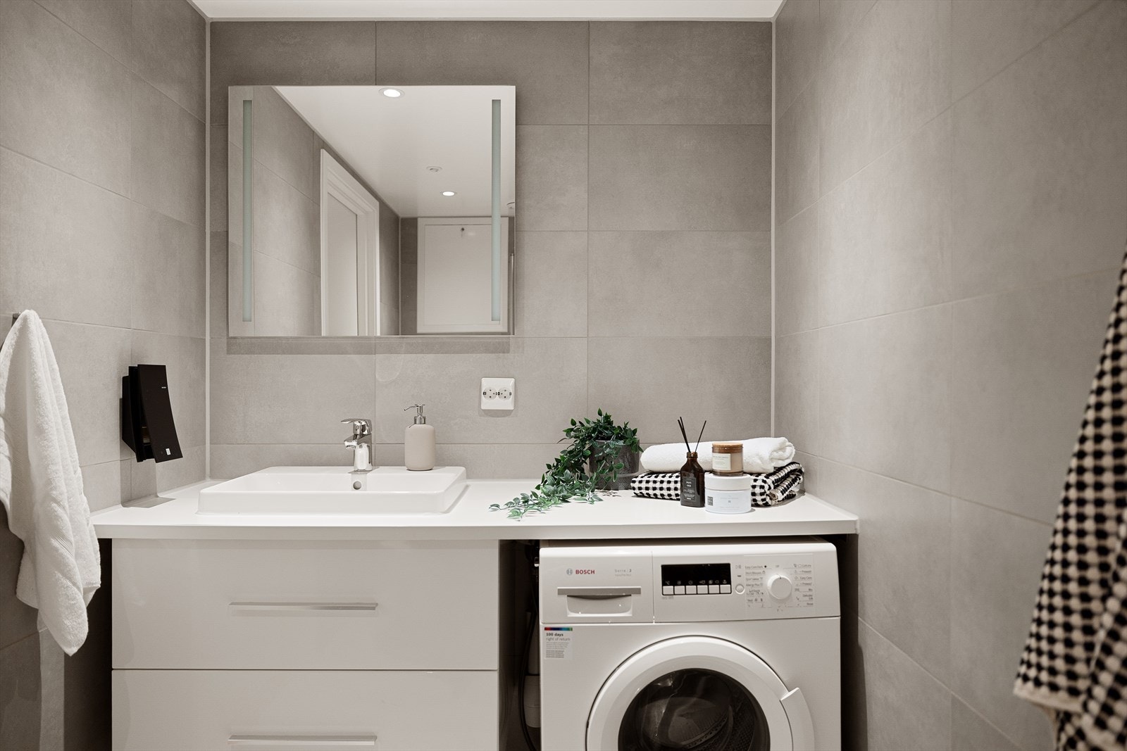 Baderommet har innredning med nedfelt servant, veggmontert toalett, dusjvegger/hjørne og opplegg for vaskemaskin. Galleribilde