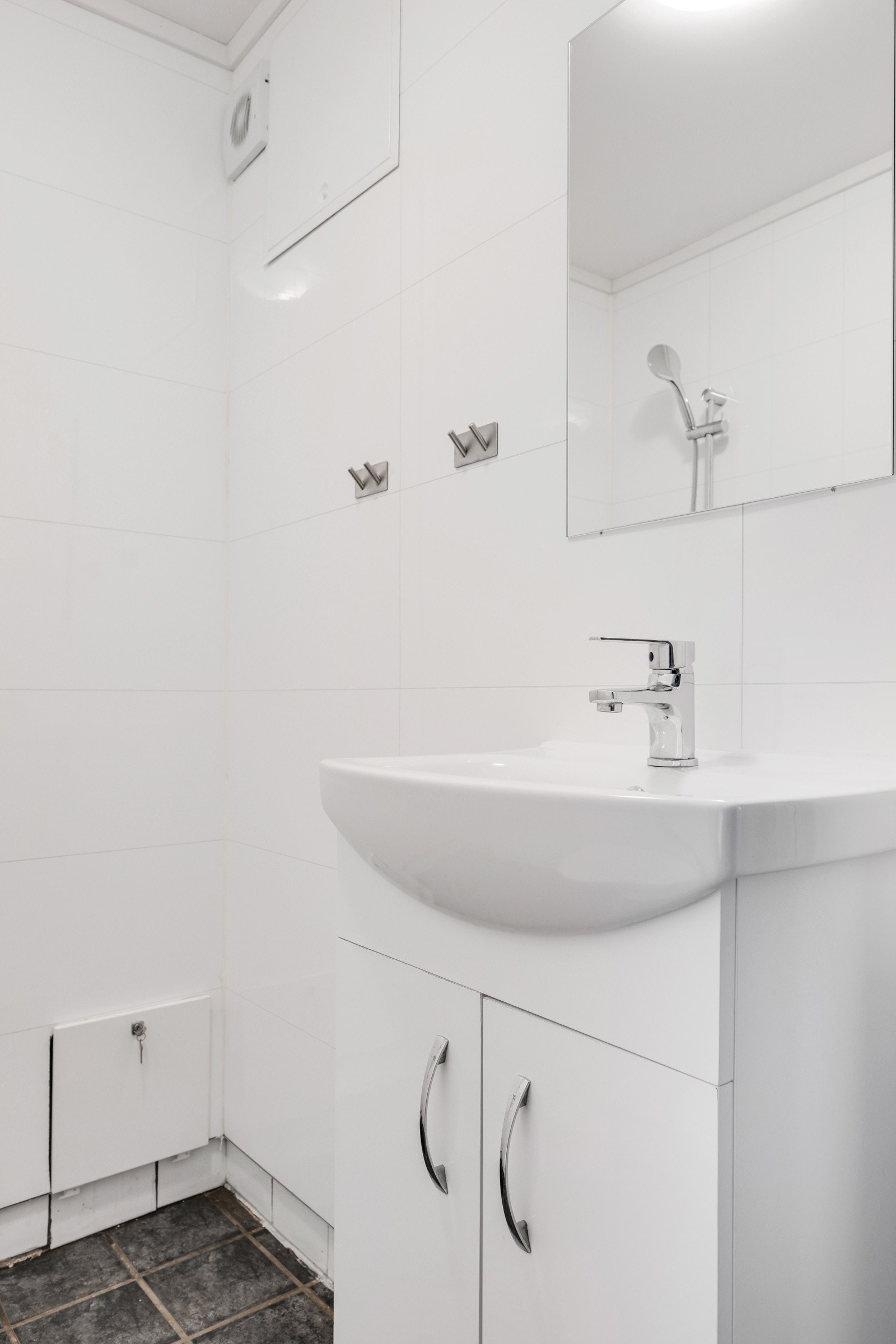 Badet er innredet med heldekkende servant, gulvmontert toalett og dusjhjørne. Galleribilde