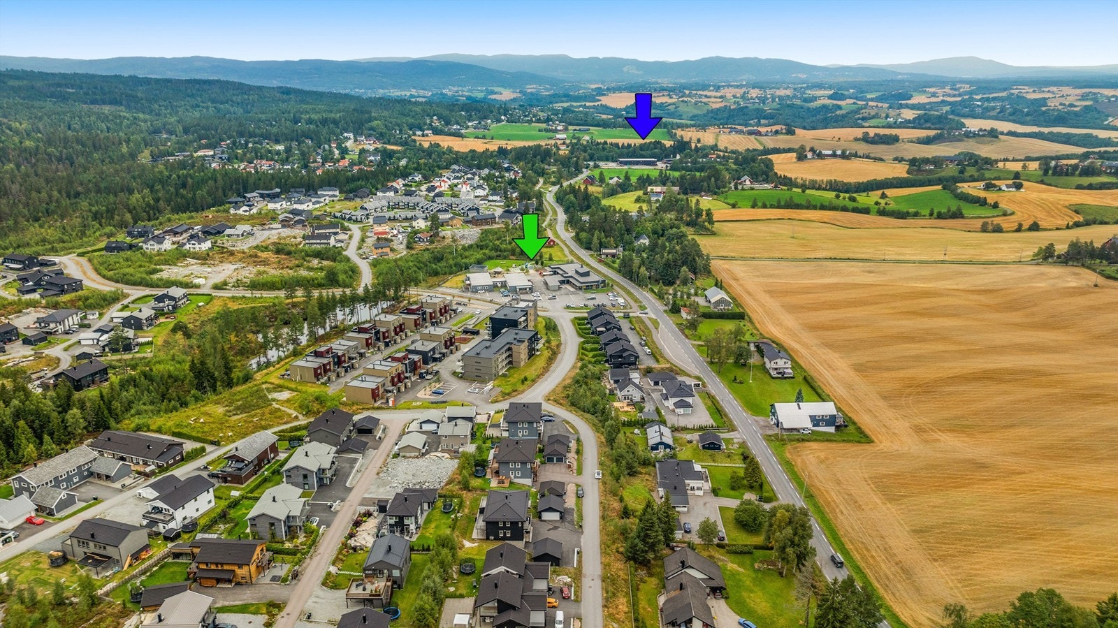 Familievennlig område med gangavstand til barnehage (grønn pil) og barneskole (blå pil). Gangveg langs hovedvegen til barneskolen. Galleribilde
