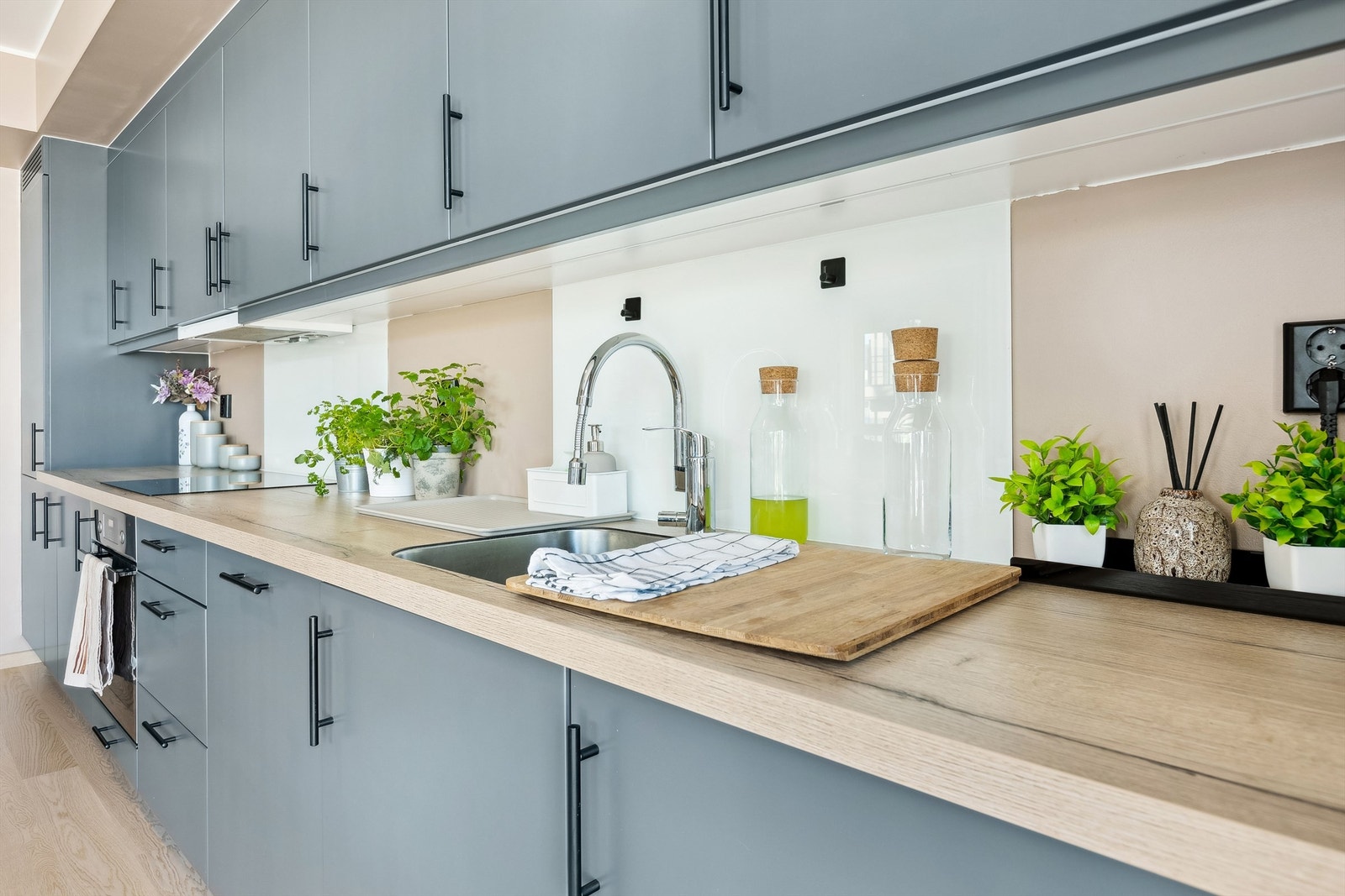 Det er glassfelter bak servant og stekeplate samt nedfelt oppvaskkum med ettgreps armatur Galleribilde