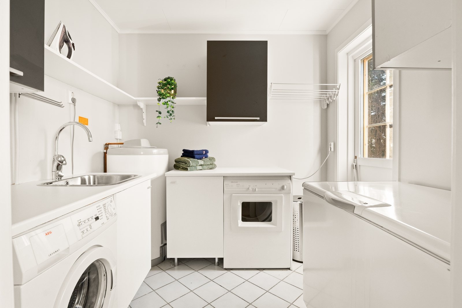 Praktisk vaskerom med god benkeplass og skapinnredning Galleribilde