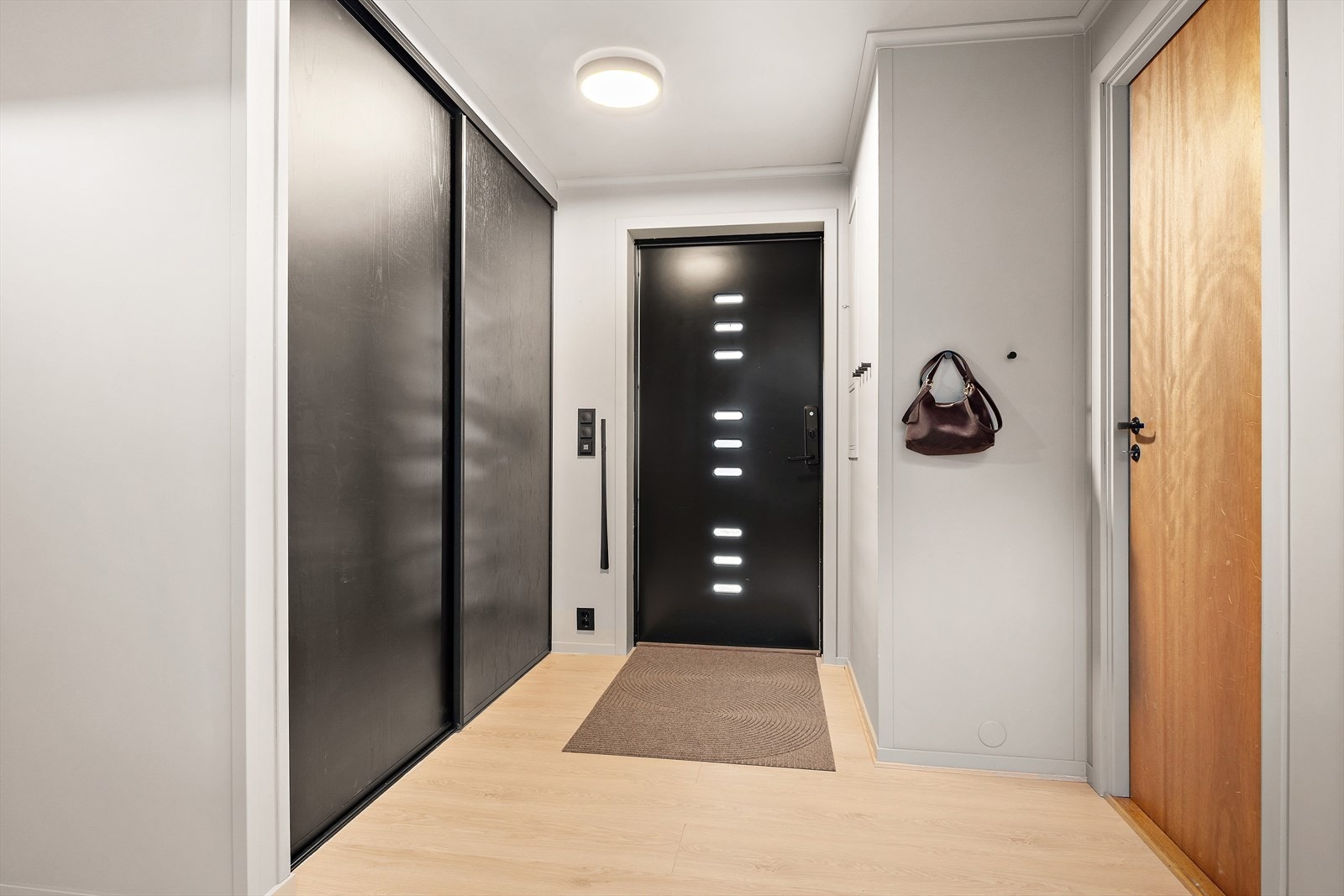 Velkommen inn til en innbydende og praktisk hall med romslig skyvedørsgarderobe. 1.etg. inneholder entre, bad, vaskerom, 1 soverom, hobbyrom og bodplass. Galleribilde