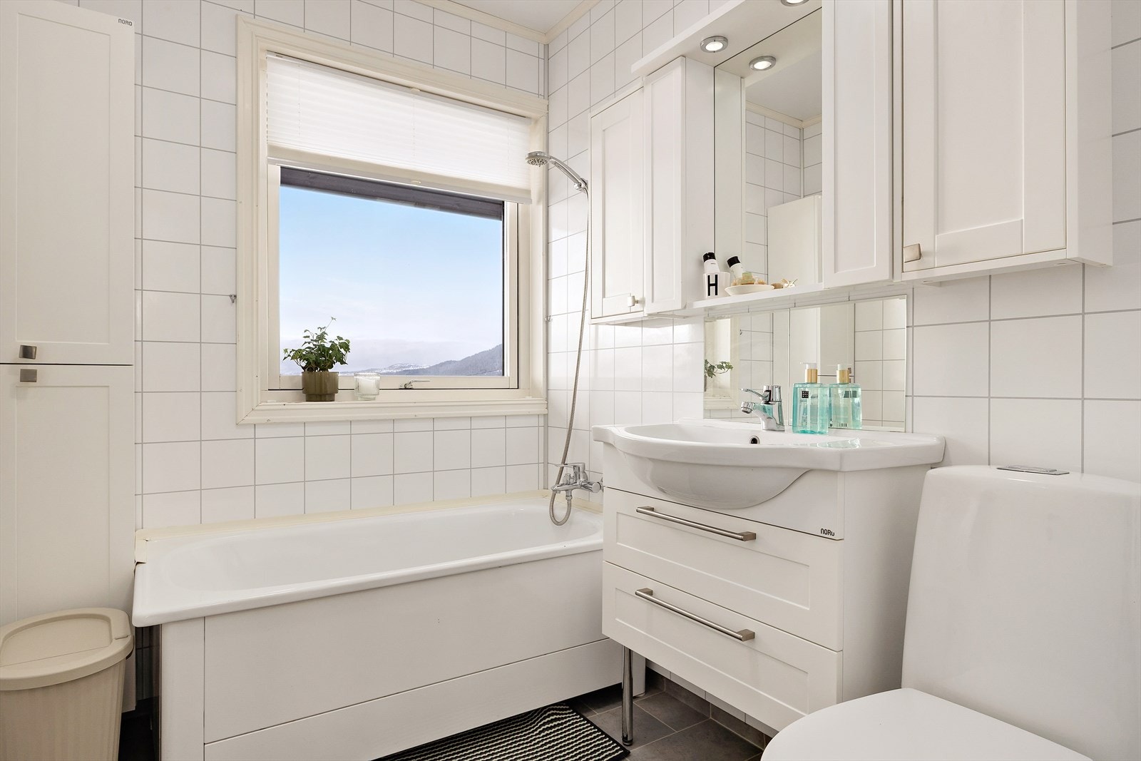 Badet på hovedplanet inneholder toalett, servant, badekar og oppbevaring. Galleribilde