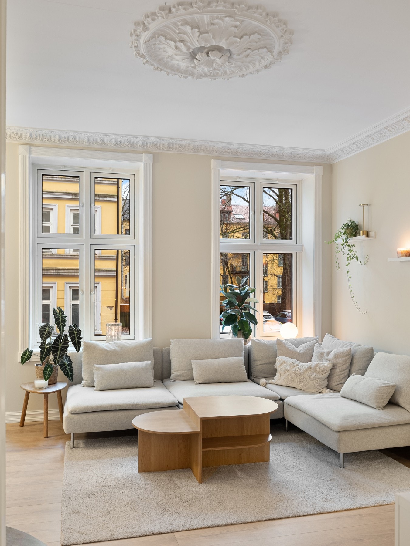 Leiligheten har en koselig stue med klassiske detaljer som stukkatur og rosett i taket. Galleribilde