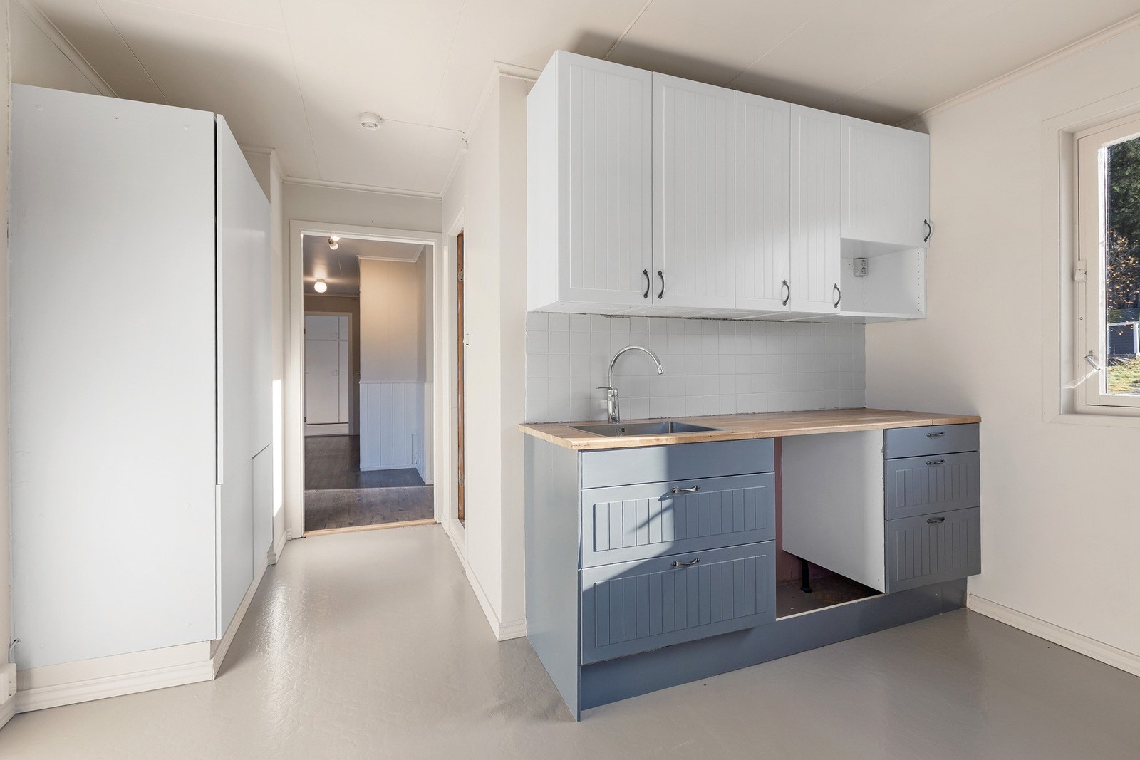 Fra kjøkken er det åpning mot gangen. Store vinduer gir naturlig lysinnslipp. Galleribilde