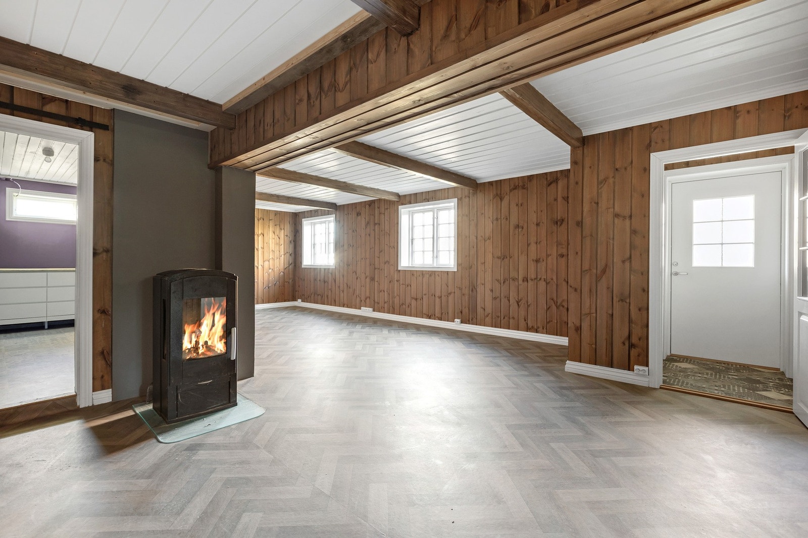 Disp. rom innredet som kjellerstue med peis, panelvegger, takbjelker og store vinduer som gir godt med naturlig lys. Rommet er ikke byggemeldt og omsøkt til sitt bruk. Galleribilde