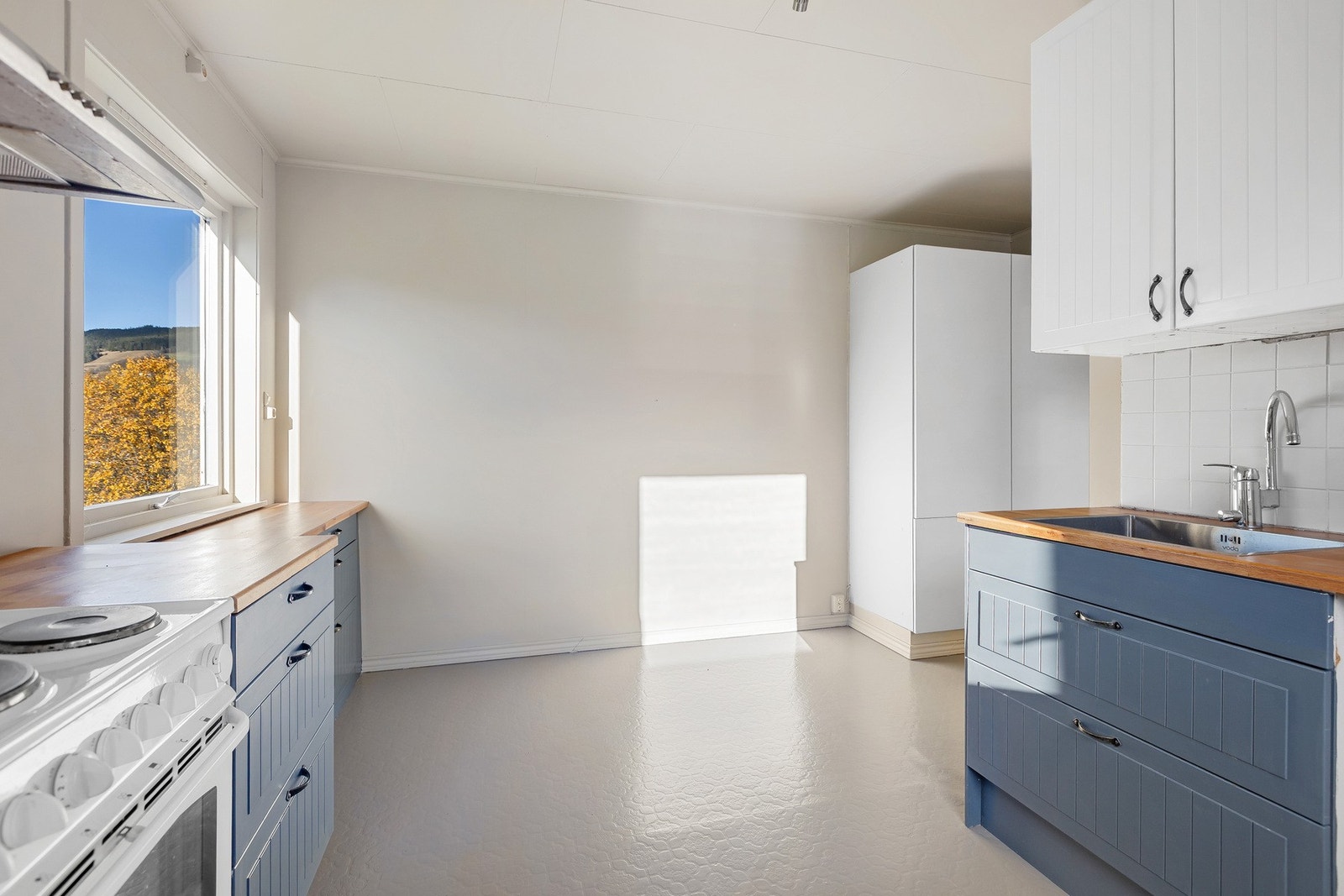 Et romslig kjøkken med plass til kjøkkenbord og stoler. Galleribilde