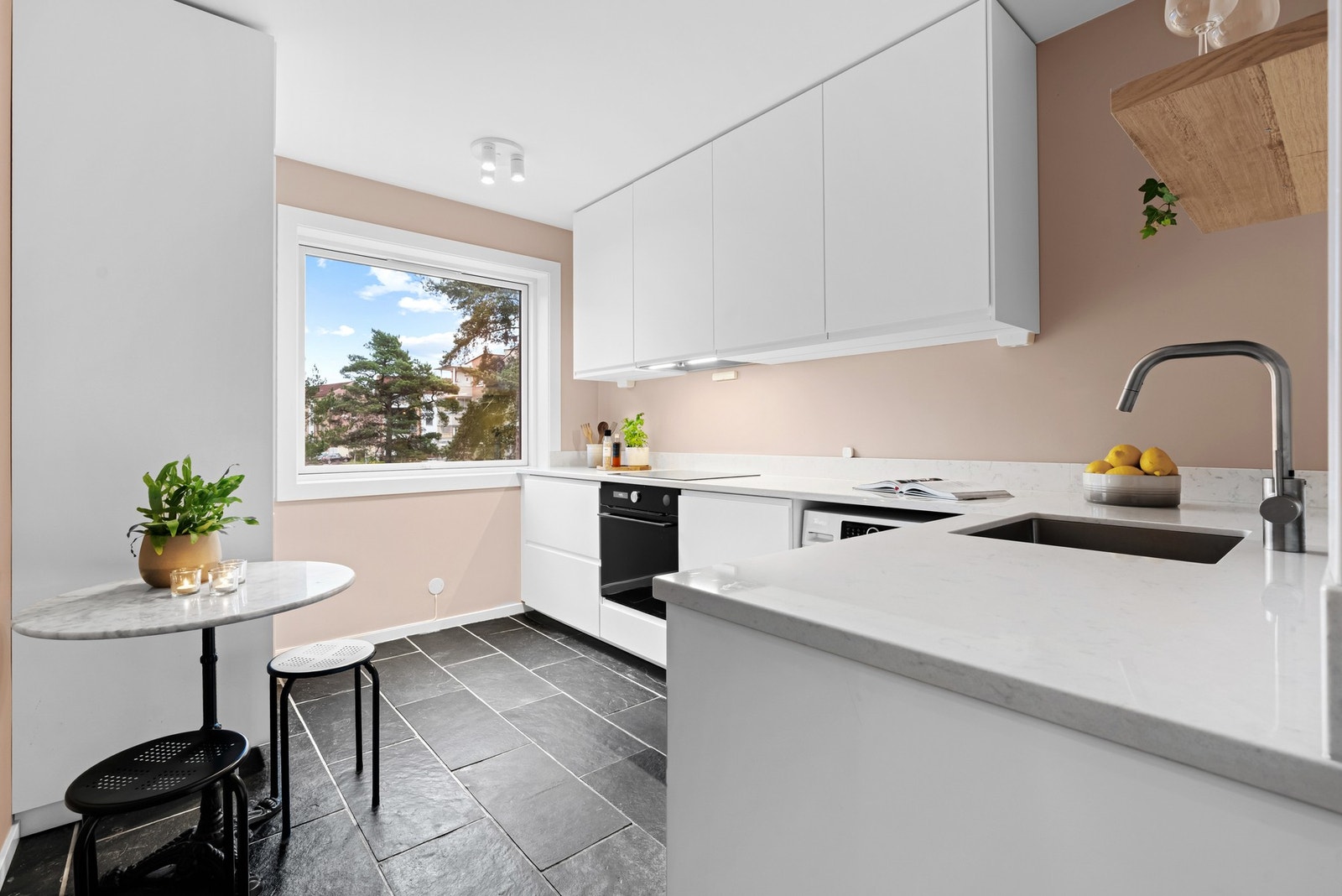 Kjøkkenet ligger i eget rom og ble lekkert pusset opp i 2023. Rommet har samme skiferfliser som i gangen, og det er også gulvvarme på kjøkkenet. Galleribilde