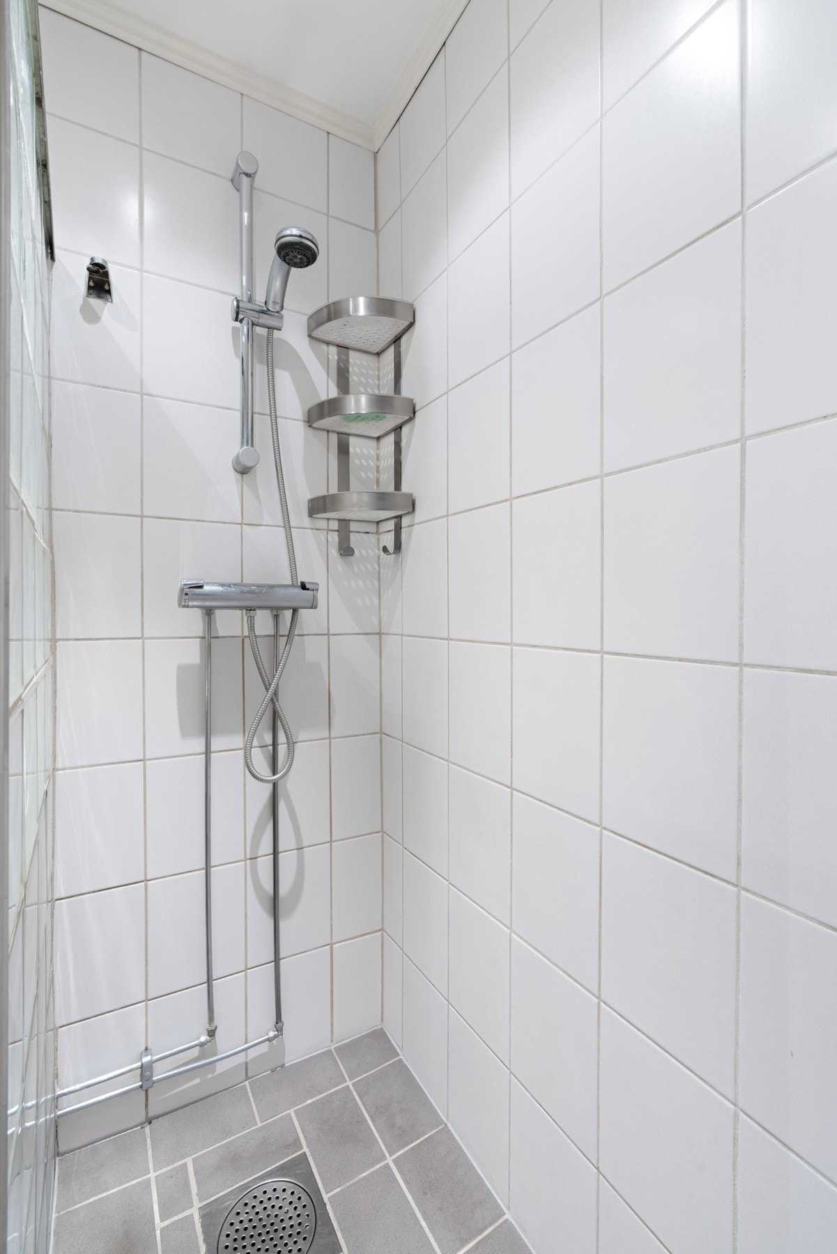 Dusjsonen er adskilt med skillevegg av glassbyggerstein og det er montert dusj med 2 - greps blandebatteri. Galleribilde