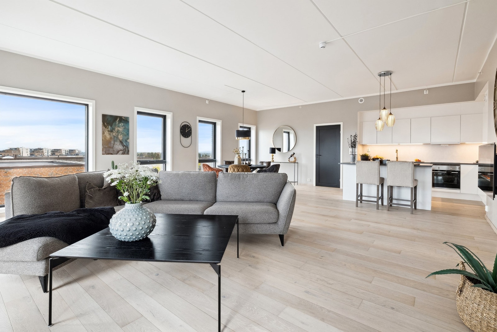 Stue og kjøkken danner et imponerende allrom med store vinduer langs begge gavlveggene Galleribilde