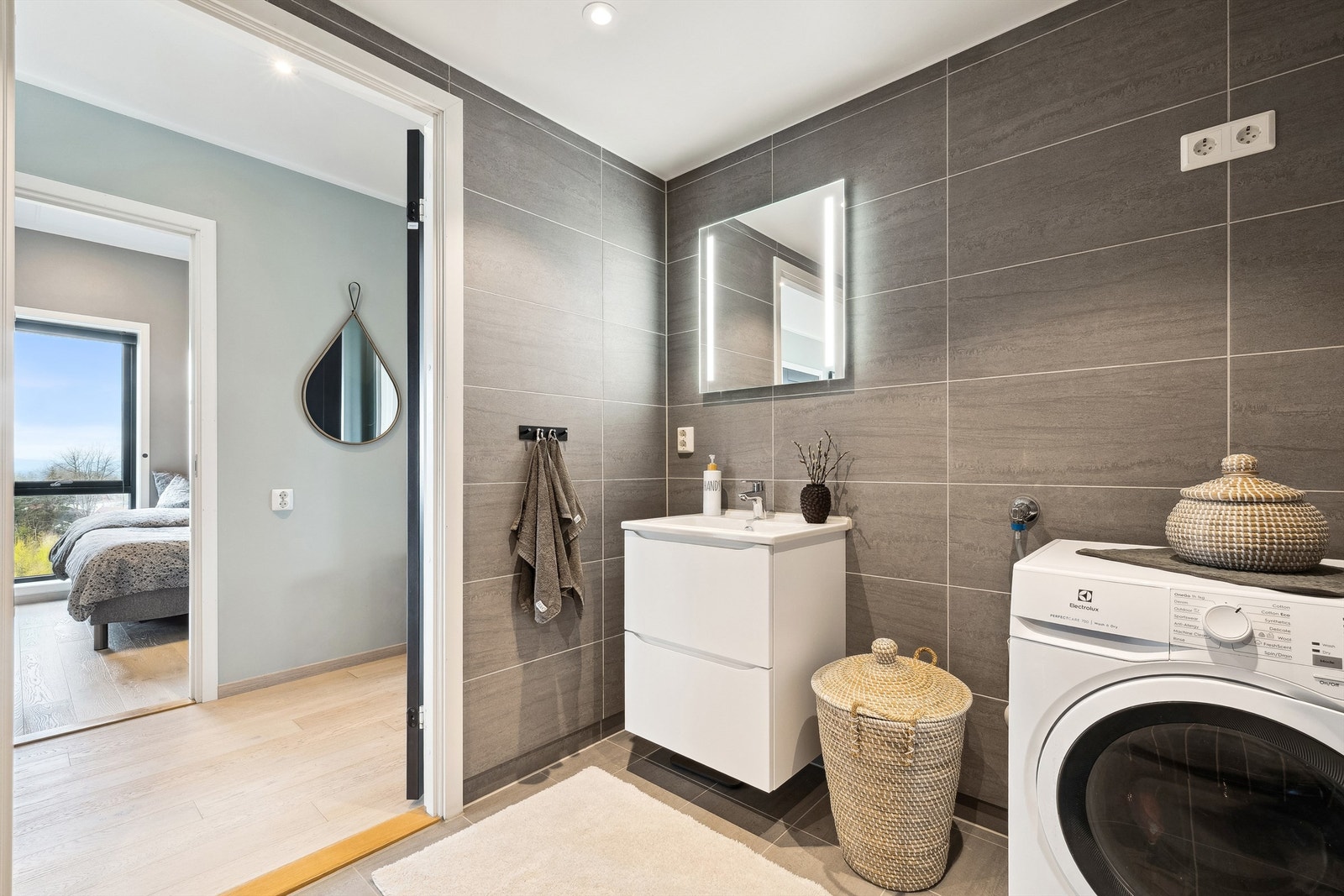 Badet med adkomst fra entreen har vaskesøyle med opplegg for vaskemaskin og tørketrommel Galleribilde