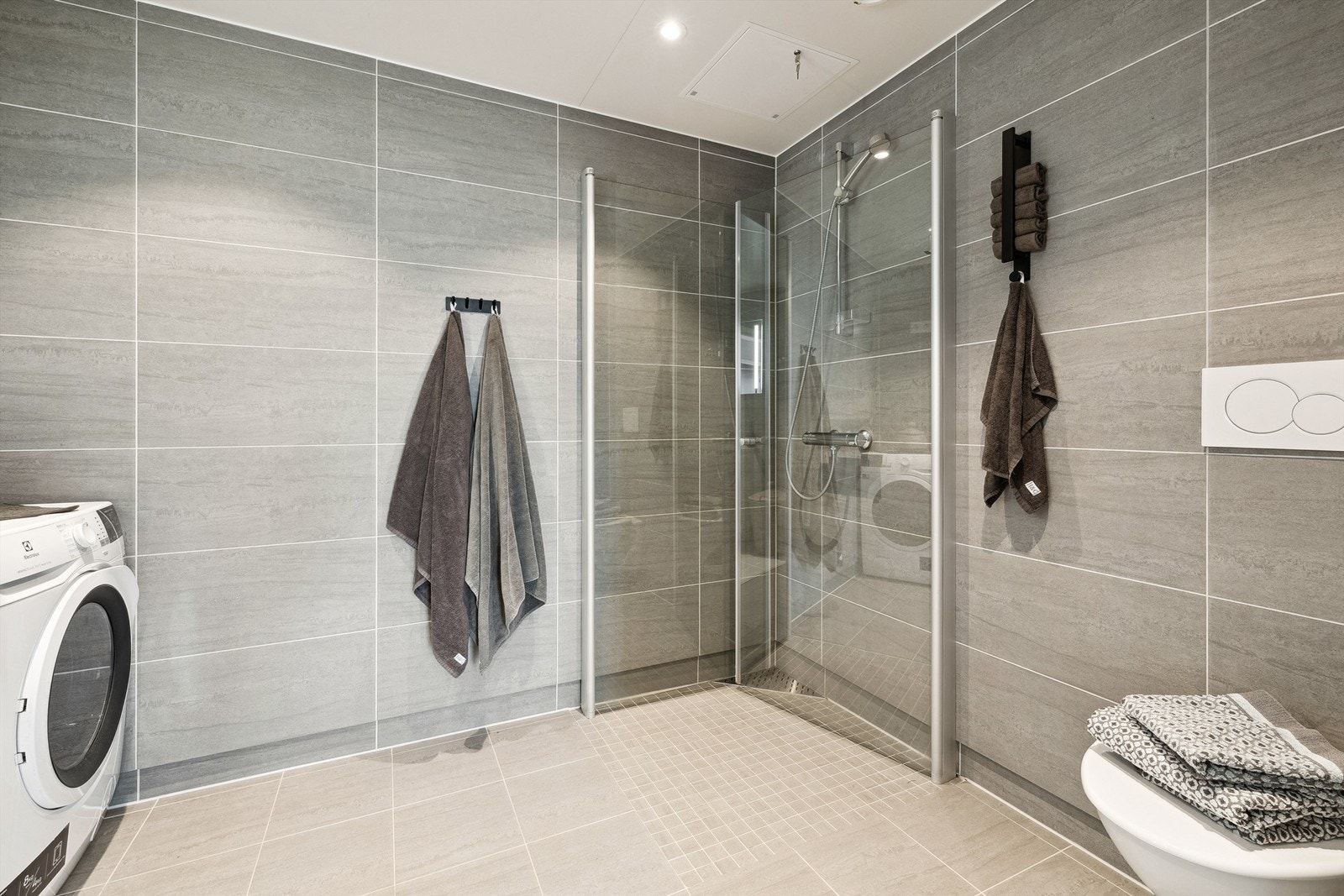 Badene har flislagte overflater, varme i gulvet og downlights i himling Galleribilde