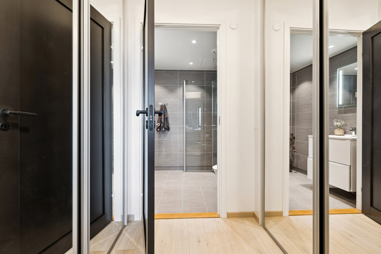 Garderoben har rikelig med oppbevaringsplass i skyvedørsgarderober langs to parallelle vegger Galleribilde