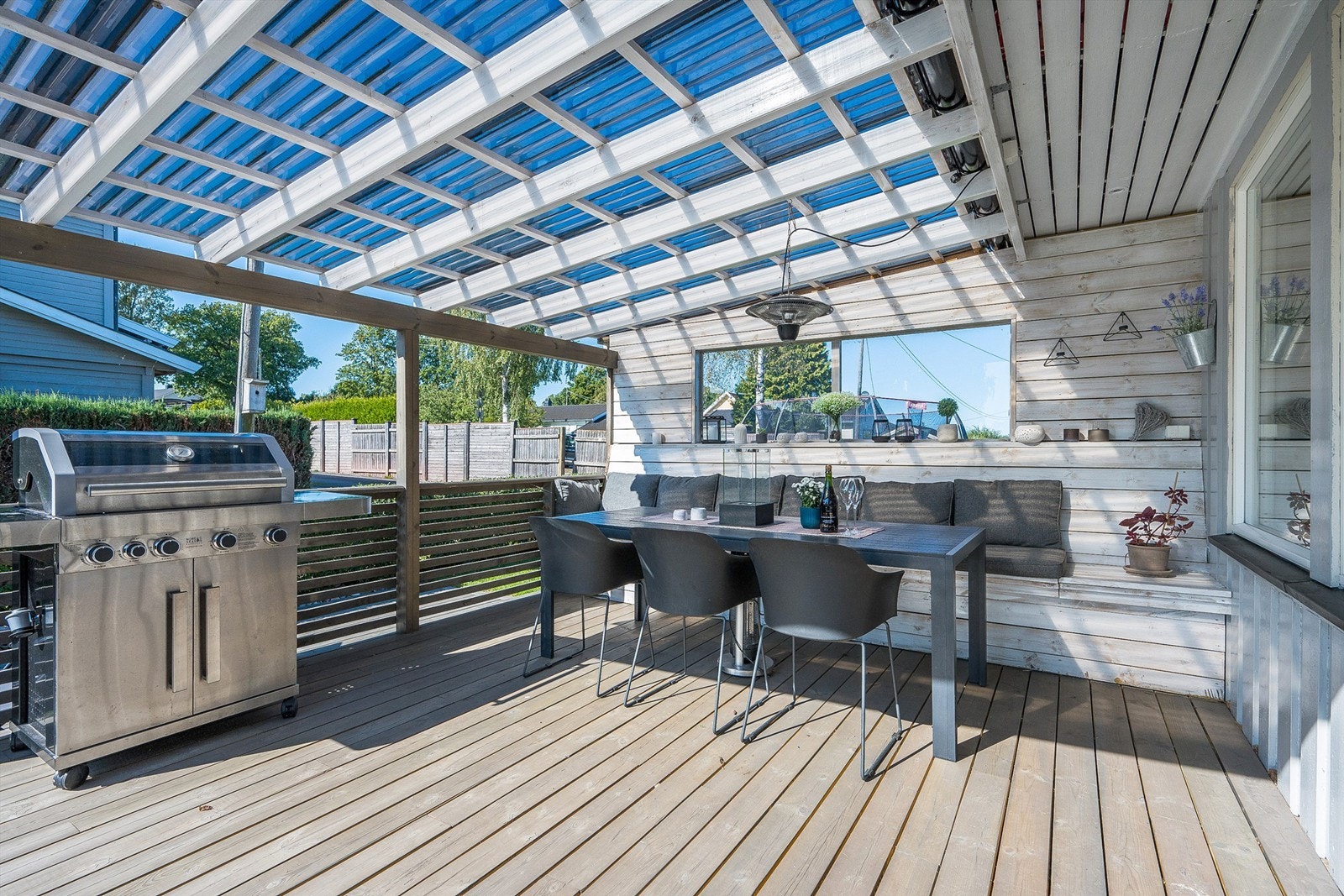 Overbygd terrasse mot vest med plassbygde hyller og benker Galleribilde