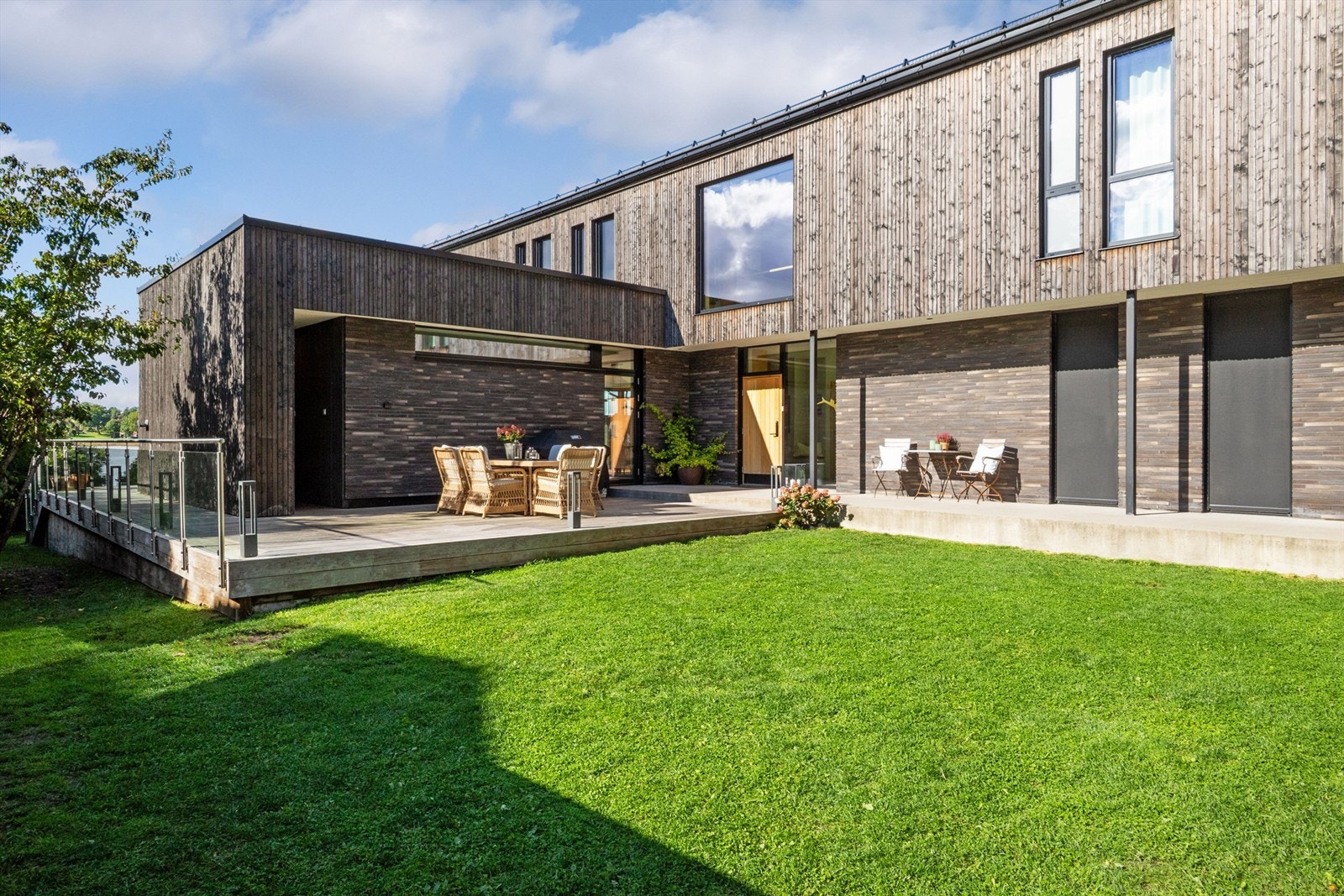 På fremsiden av huset er det opparbeidet en oase med gressplen og terrasse - atriumet har morgen/formiddagssol og liger usjenert og lunt til. Galleribilde