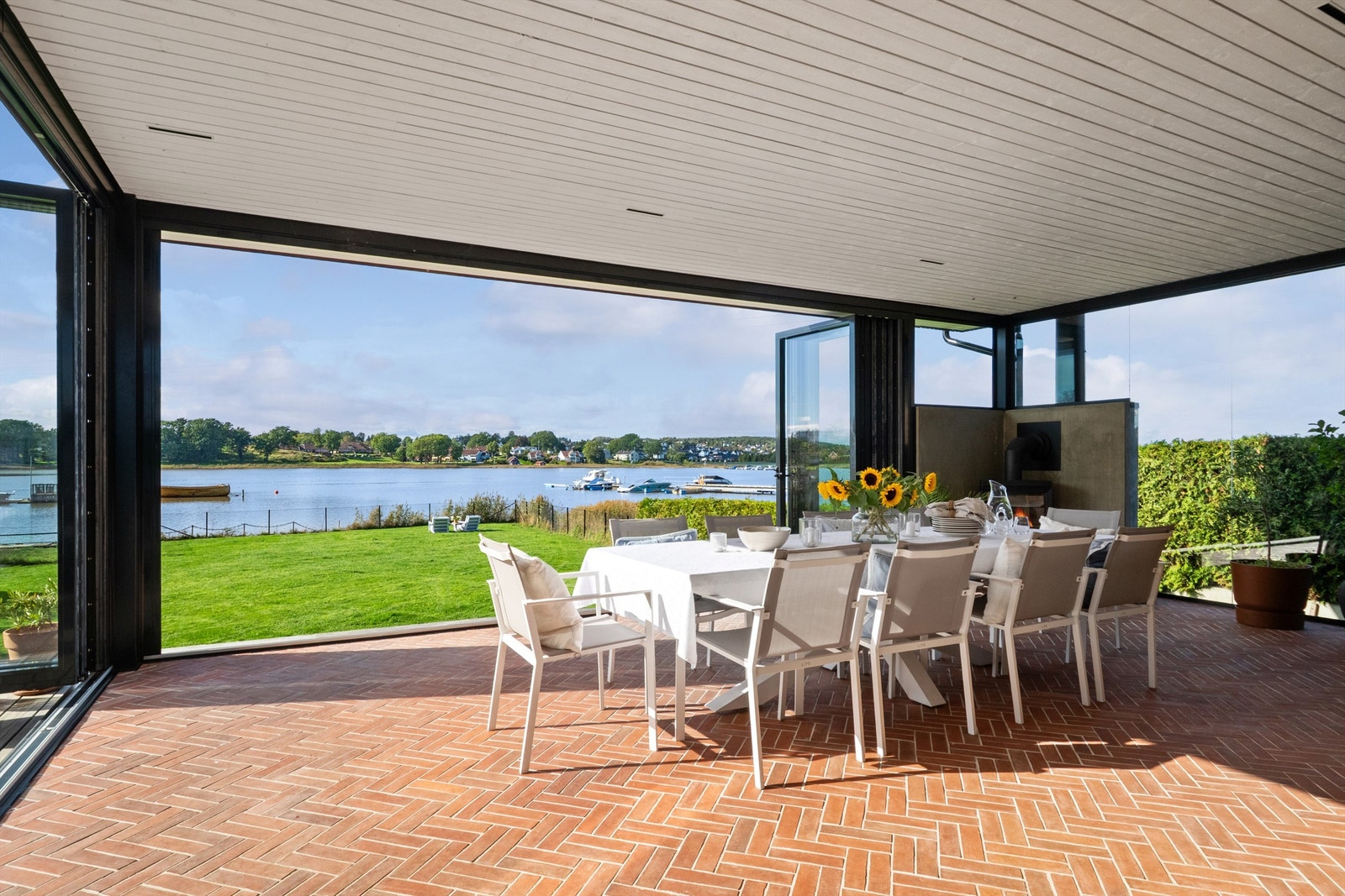 Gulvet er lagt i flott tegelstensfliser og det er store foldedører . Galleribilde