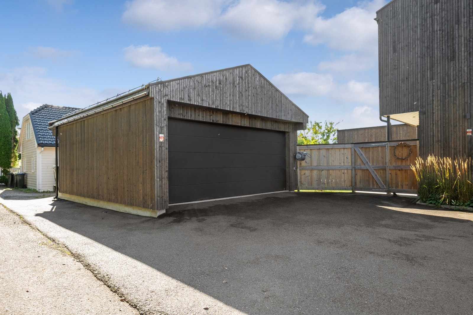 I gårdsplassen er det asfaltert foran garasjen og på biloppstillingsplassene. Galleribilde