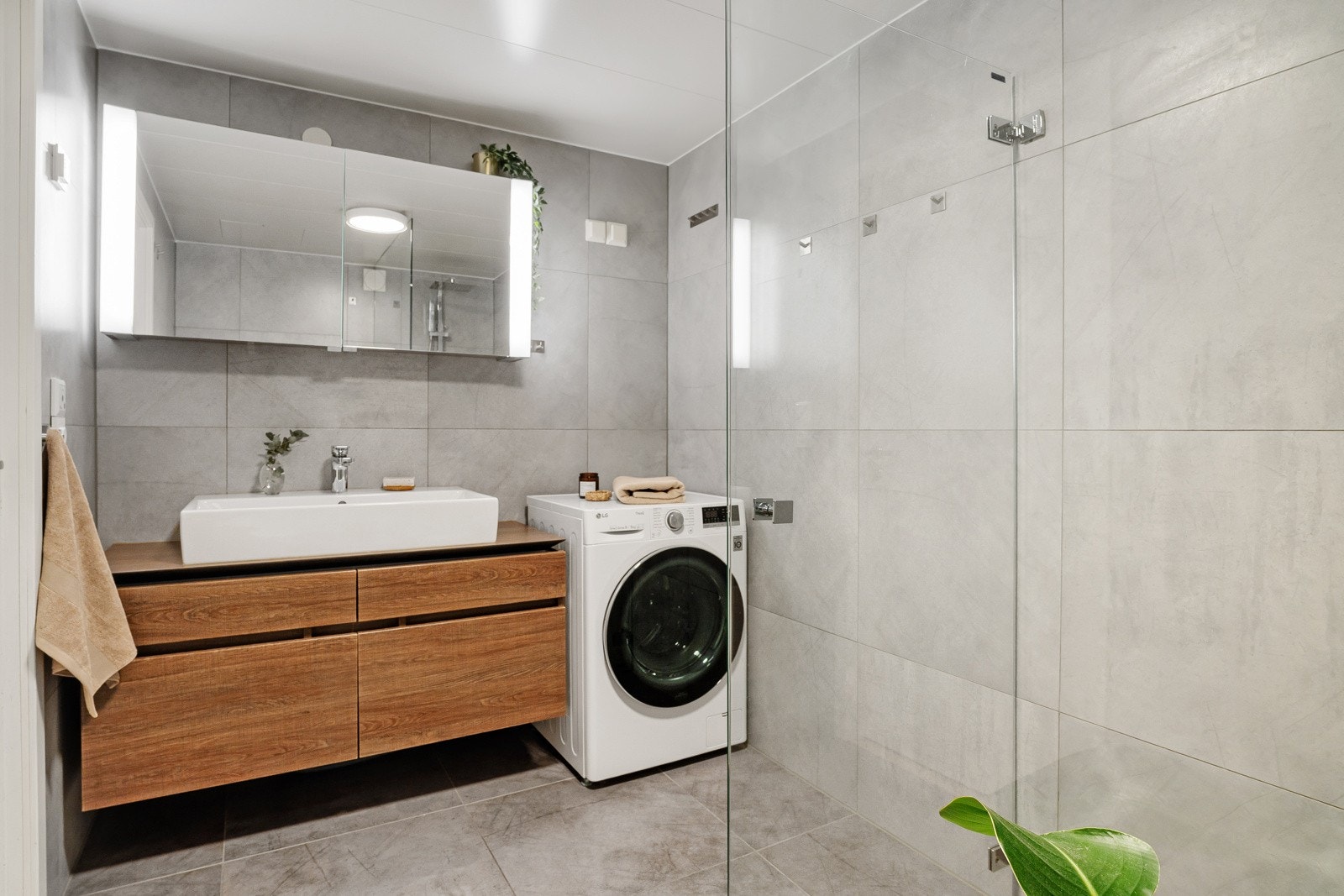 Pent flislagt bad innredet med med varmekabler, dusjnisje med svingbar dusjvegg. Opplegg for vaskemaskin. Galleribilde