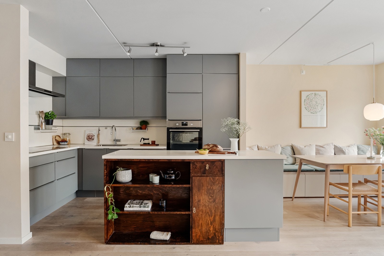 Pent kjøkken fra HTH med moderne, slette fronter og overskap med integrert benkebelysning Galleribilde