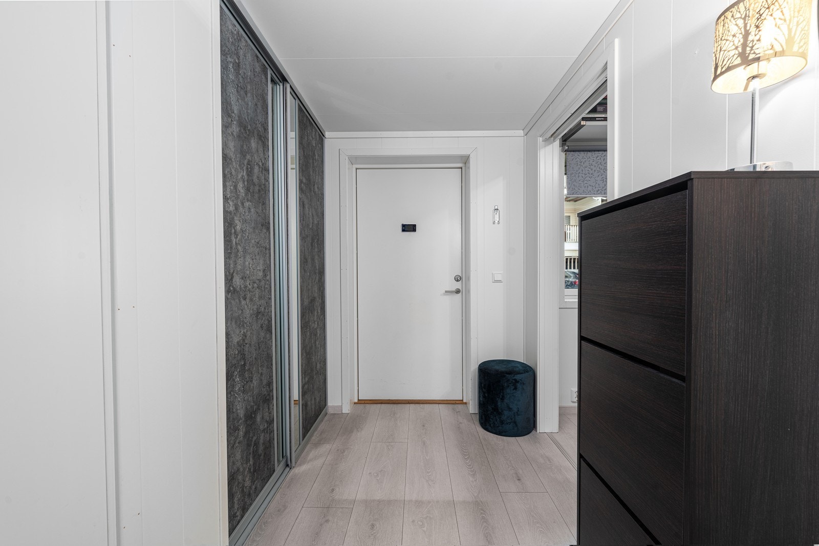Velkommen inn i en lys entré med en stor skyvedørsgarderobe for praktisk oppbevaring. Galleribilde