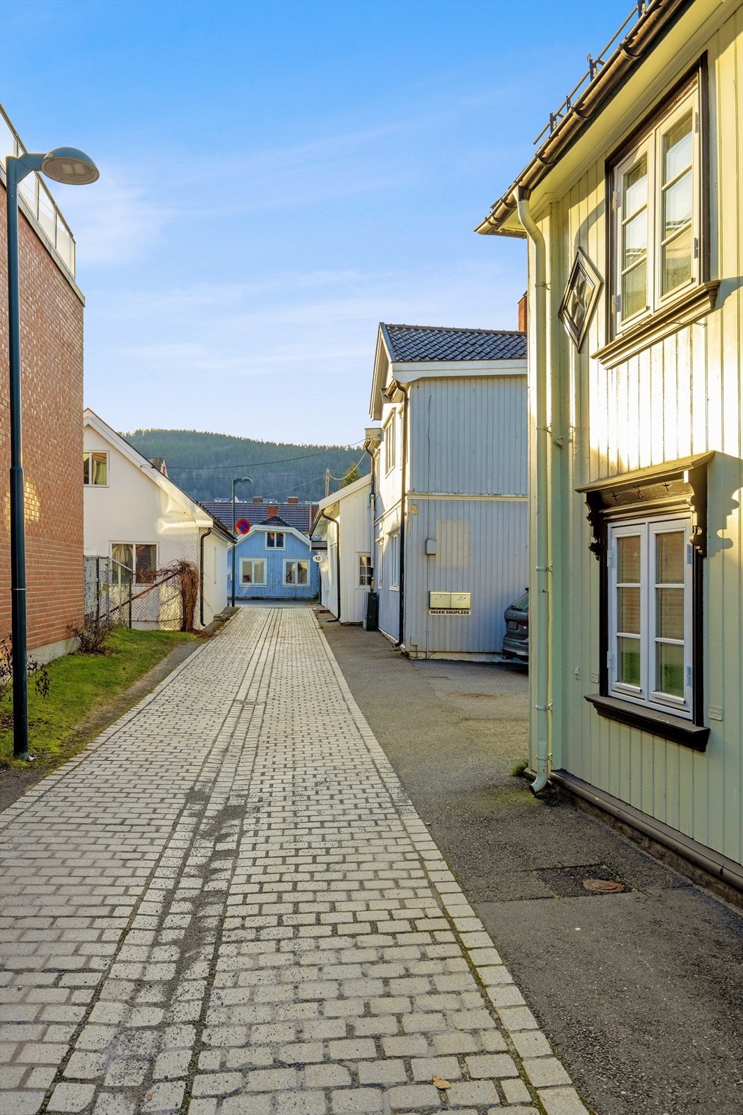 Brosteinsbelagt gate gir en historisk følelse i bybildet. Galleribilde