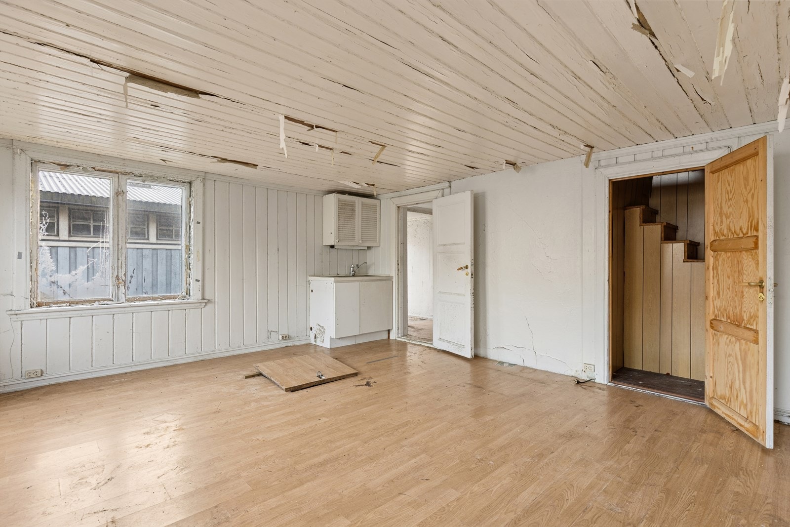 Innredning i stue med slette fronter og nedfelt kum. Adkomst til krypkjeller via luke i gulvet i stuen. Galleribilde