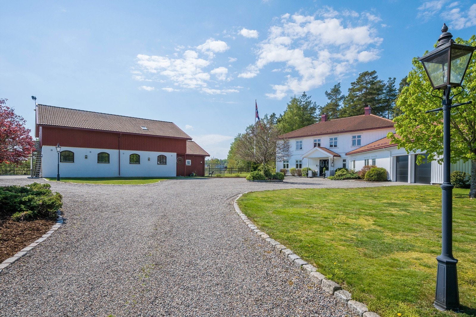 Egen oppkjørsel med innkjøring til gruset gårdsplass med rundkjøring. Tomten er usjenert og tilbaketrukket med plen og diverse beplantning. Galleribilde