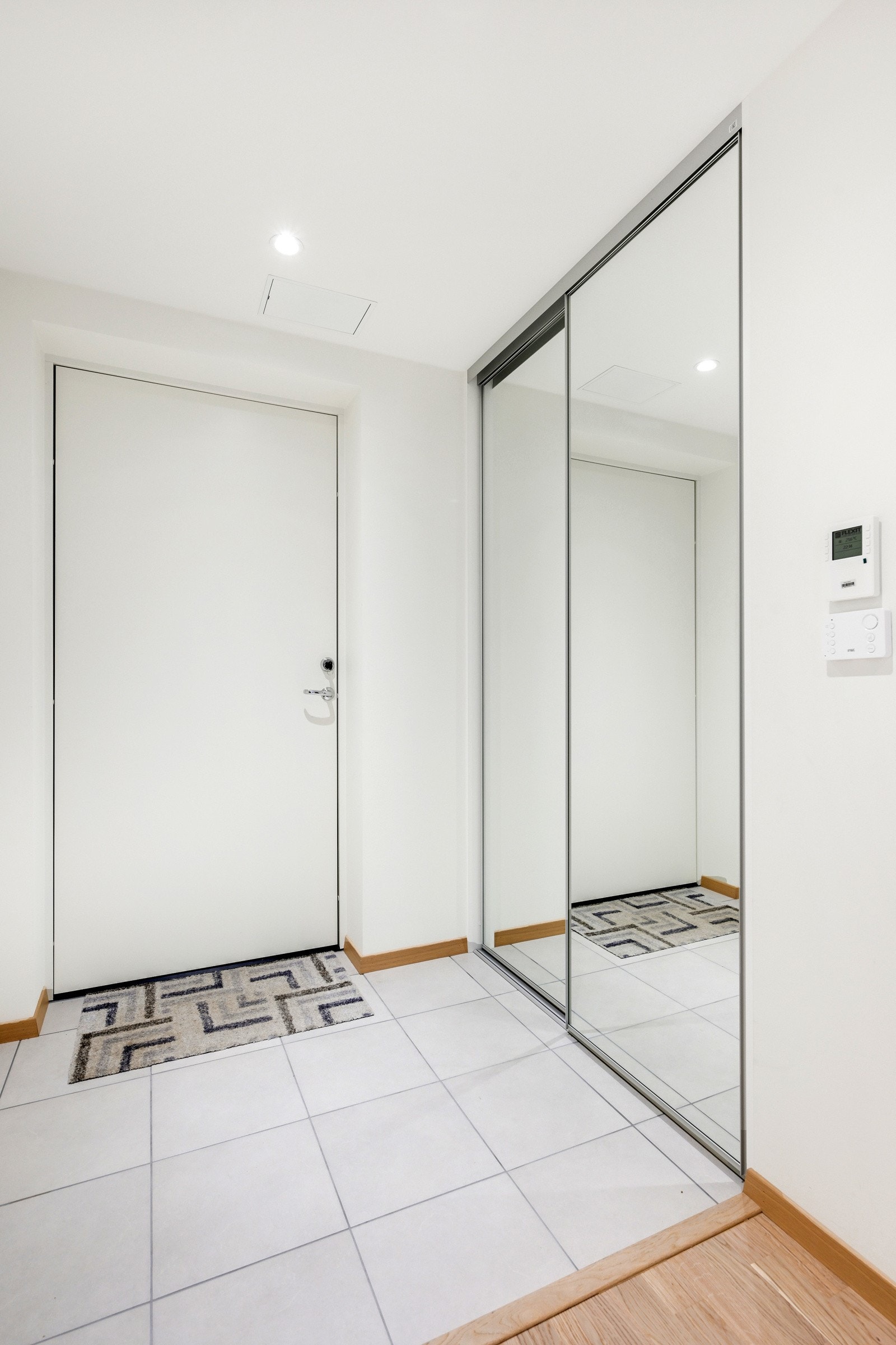 Fin og romslig entrè med lyse farger og flotte fliser på gulv. Galleribilde