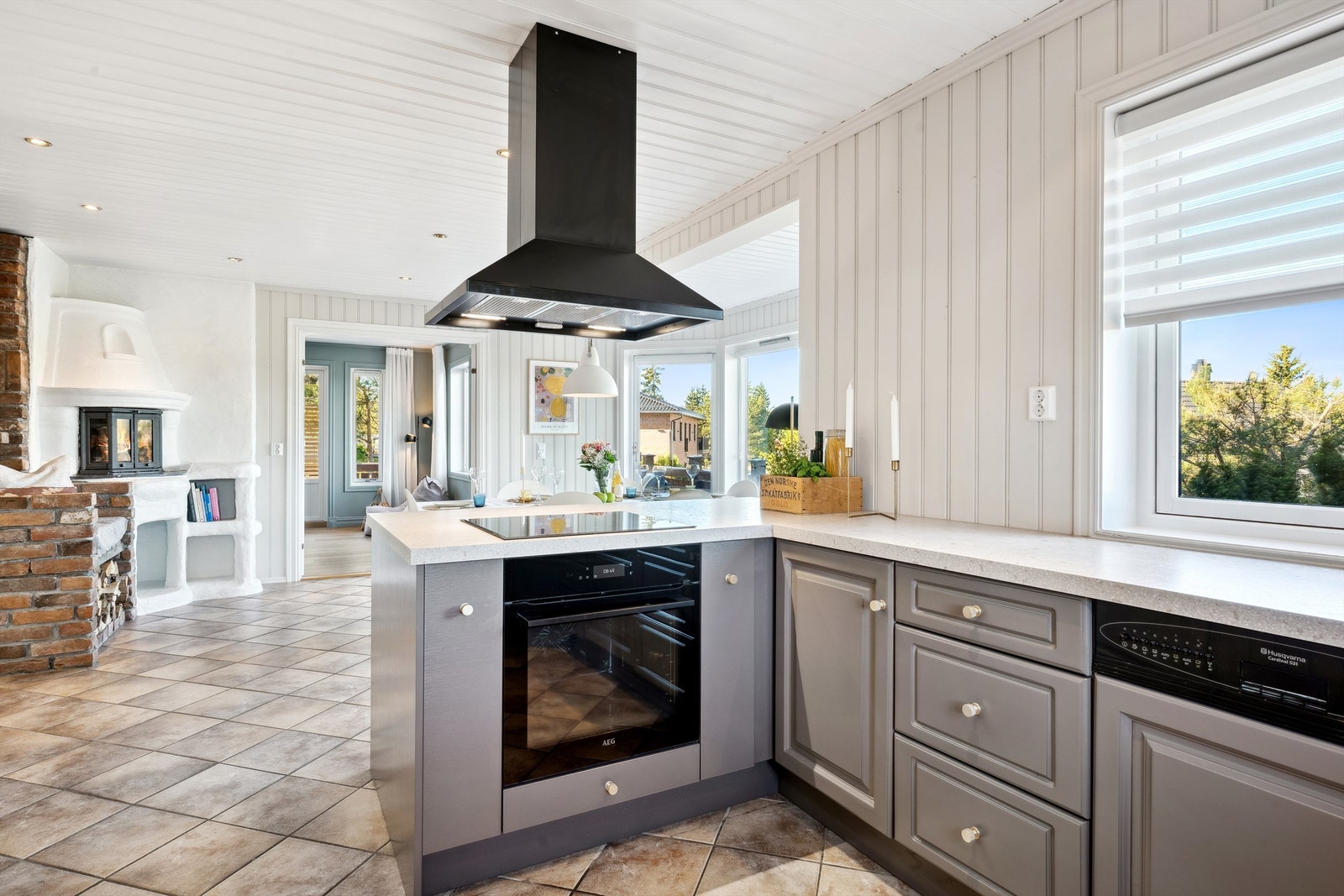 Pent kjøkken med innredning i profilerte fronter, laminert benkeplate og halvøy mot spiseplassen Galleribilde