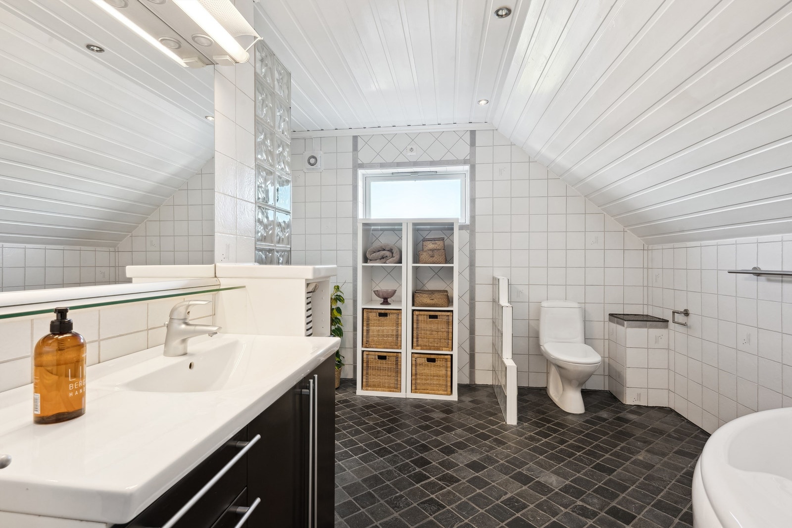 Det er romslig og innredet med toalett. dusjvegger/hjørne, badekar og innredning med nedfelt servant Galleribilde