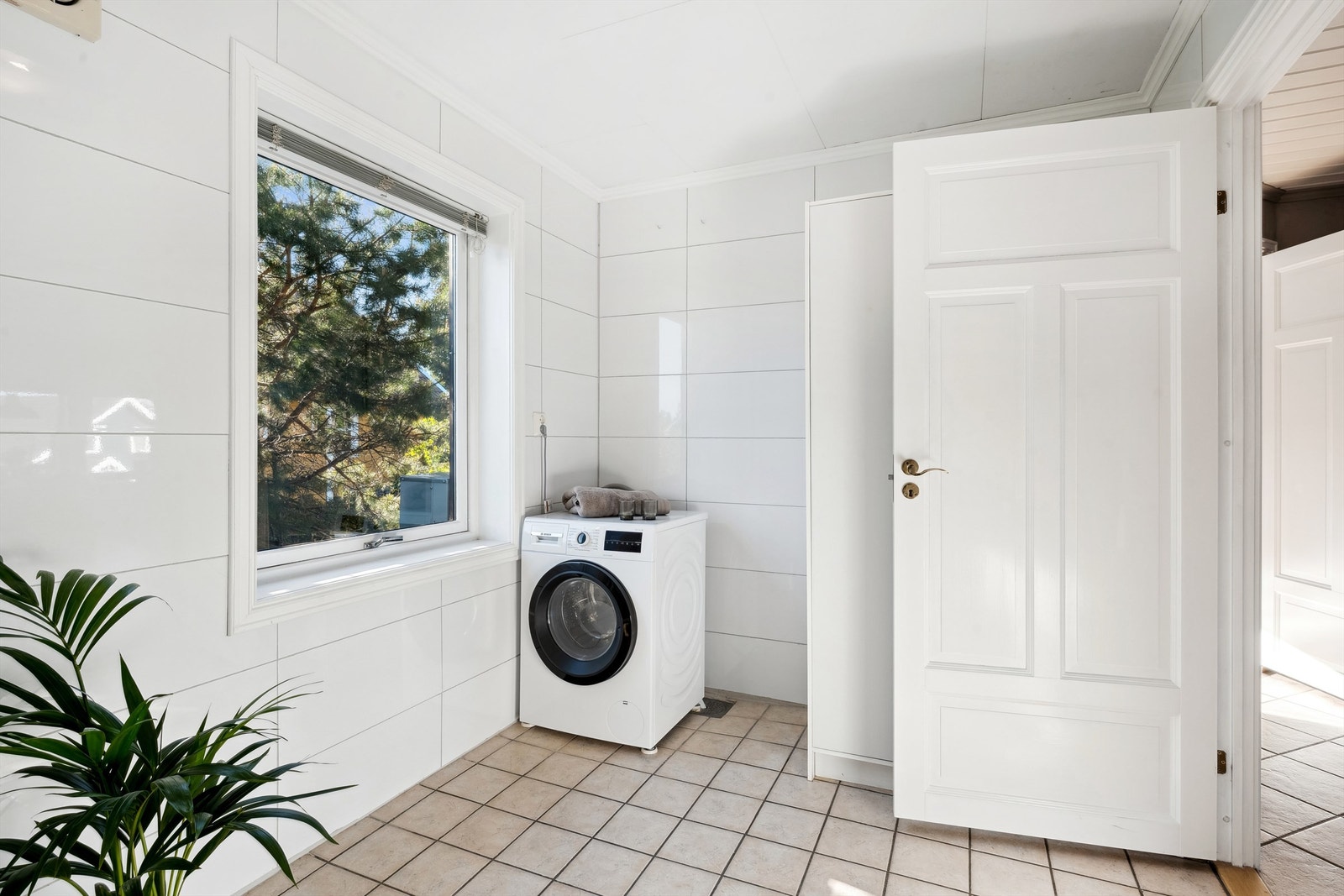 Badet er innredet med dusjkabinett, innredning med nedfelt servant og opplegg for vaskemaskin Galleribilde