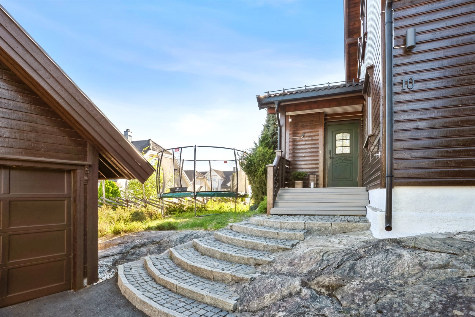 Steinbelagt trapp fører til boligens overbygde inngangsparti Galleribilde