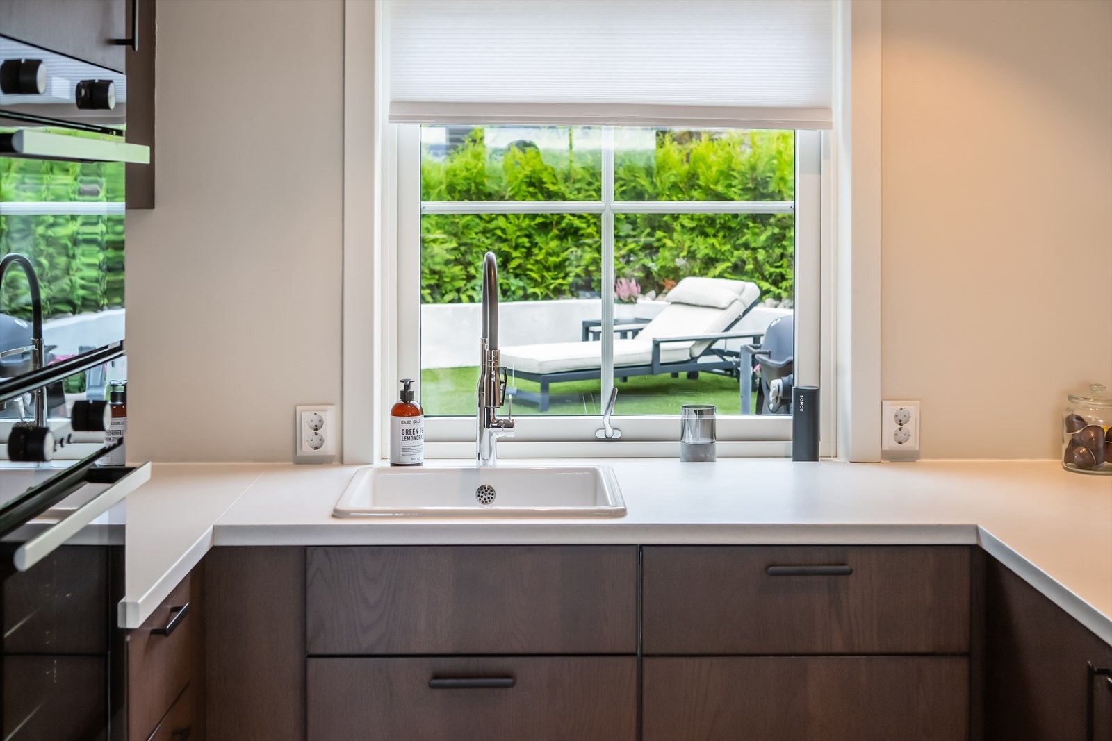 Under vinduet finner vi en nedfelt vask som gir både utsikt og naturlig lys inn i rommet, samtidig som vinduet bidrar til en luftig atmosfære. Galleribilde