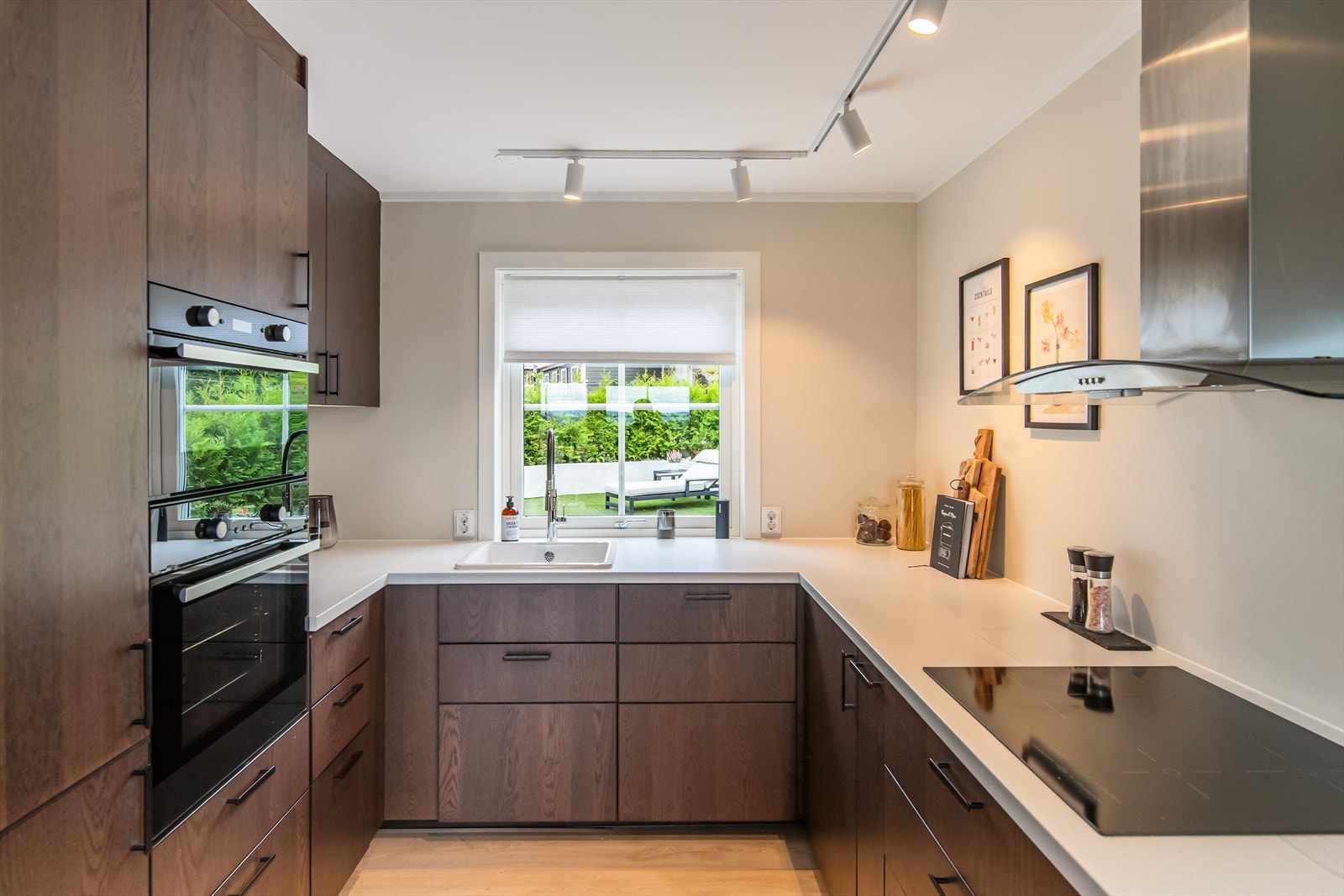 Benkeplatene i hvit laminat skaper en pen kontrast til de mørke overflatene, og gir samtidig en lys og ren arbeidsflate. Galleribilde