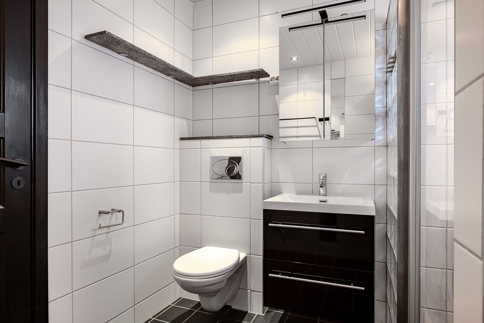 Badet med dusj, servant med speilskap og vegghengt toalett. Galleribilde