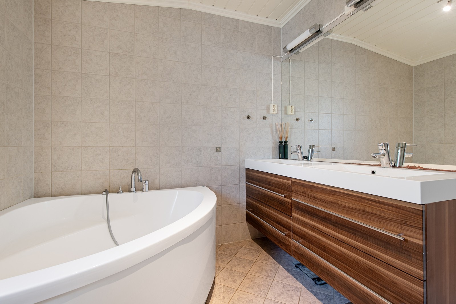 Badet har fliser på vegger og gulv med elektriske varmekabler Galleribilde