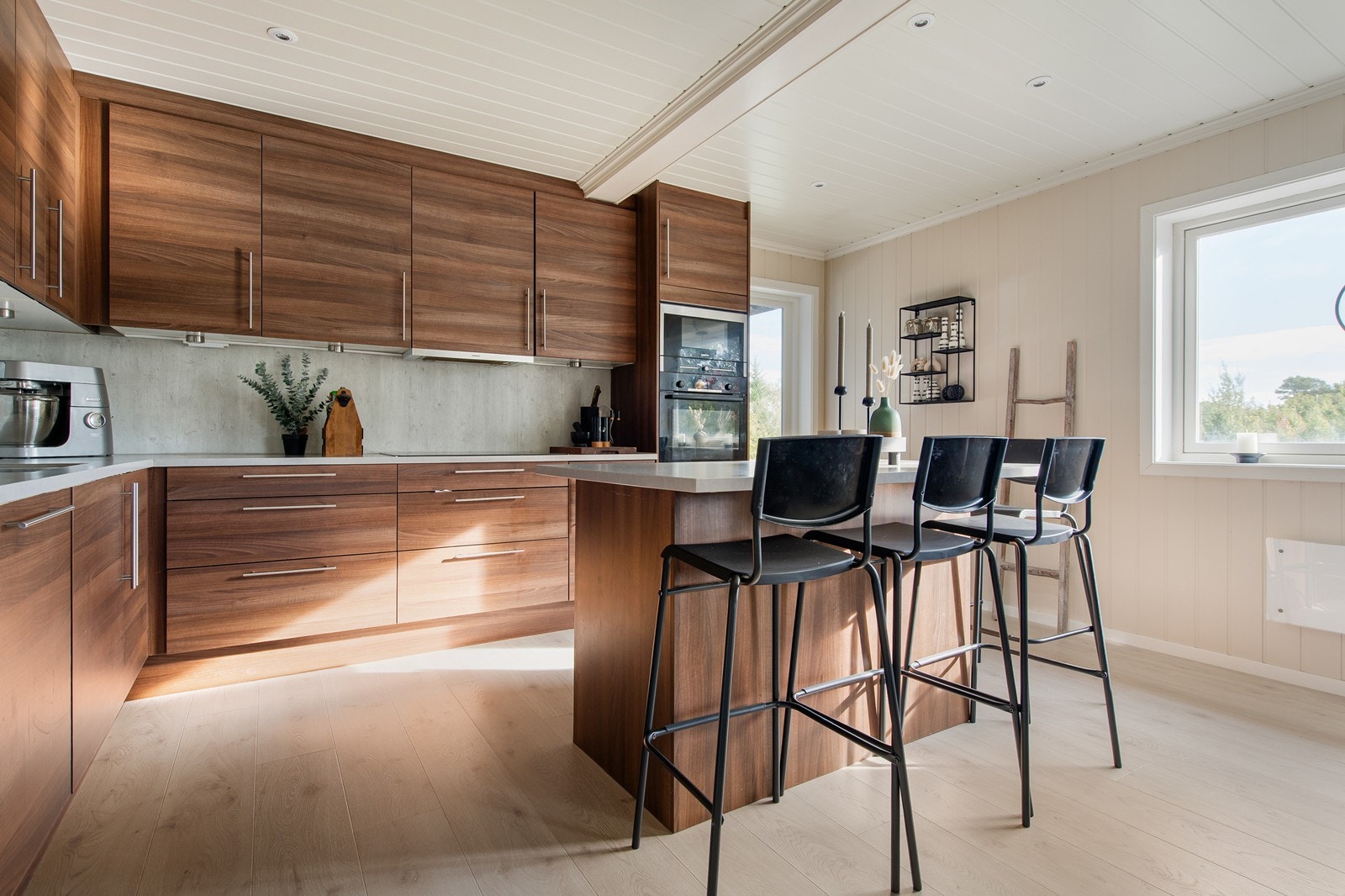 Kjøkkenet har innredning med glatte fronter og benkeplate av laminat Galleribilde