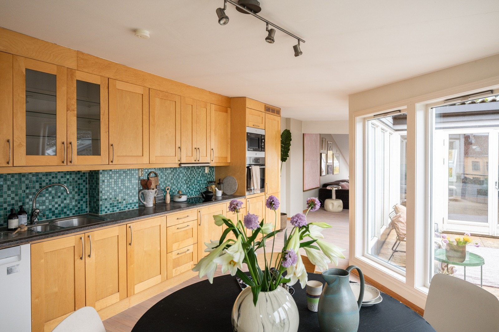 Kjøkkeninnredning fra 2004 med god skap- og benkeplass. Innredningen har profilerte fronter og laminert benkeplate med nedfelt oppvaskkum. Praktisk med mosaikkfliser i benkeryggen og belysning under de takhøye overskapene. Galleribilde