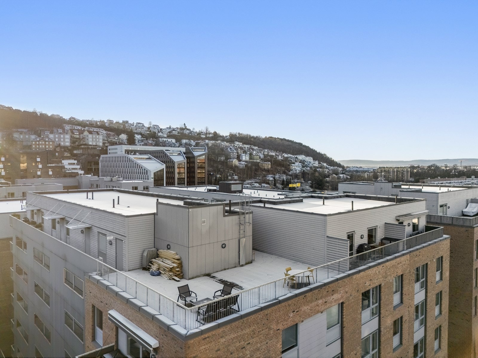 Dronebilde av fellestakterrasen og leiligheten. Galleribilde