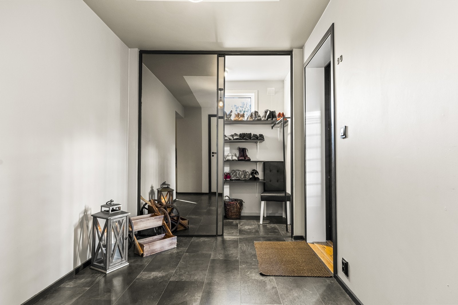 Romslig entré med praktisk garderobeløsning bak speilskyvedører. Galleribilde